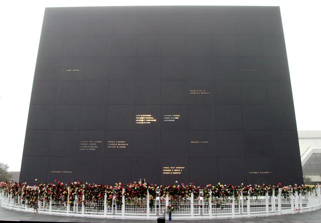 NASA image: KENNEDY SPACE CENTER, FLA. - Roses and other flowers ring the base of the Astronaut Memorial Mirror at the KSC Visitor Complex following a memorial service held for the crew of Columbia on the anniversary of the tragic accident that took their lives Feb. 1, 2003.  The public was invited to the service and encouraged to place the flowers on the fence.  The service included comments by Center Director Jim Kennedy, Deputy Director Woodrow Whitlow Jr., Executive Director of Florida Space Authority Winston Scott, and Dr. Stephen Feldman, president of the Astronaut Memorial Foundation.  The black granite mirror honors astronauts, whose names are carved in the surface, who have given their lives for space exploration.