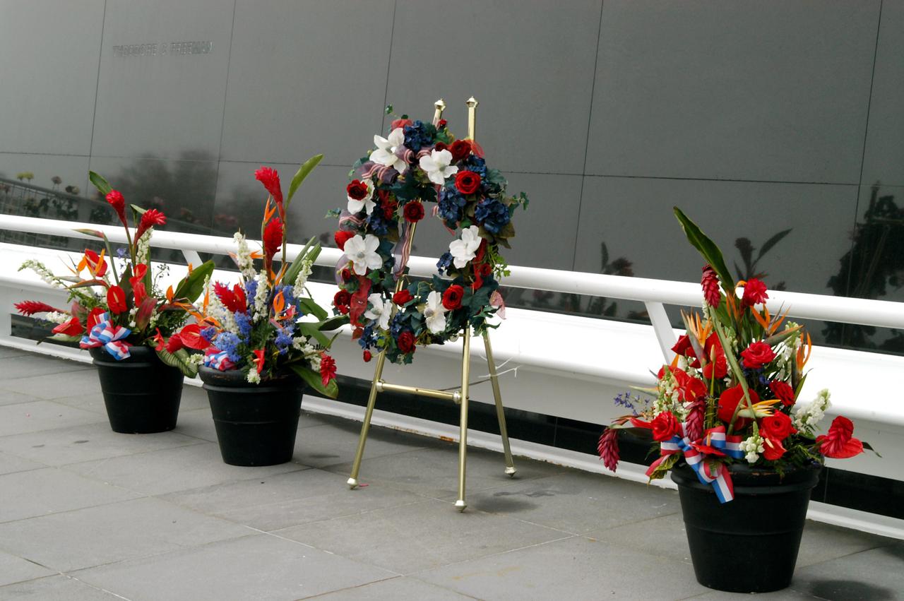 KENNEDY SPACE CENTER, FLA. - A wreath and other floral arrangements rest beneath the Astronaut Memorial Mirror at the KSC Visitor Complex following a memorial service held for the crew of Columbia on the anniversary of the tragic accident that took their lives Feb. 1, 2003.  The service included comments by Center Director Jim Kennedy, Deputy Director Woodrow Whitlow Jr., Executive Director of Florida Space Authority Winston Scott, and Dr. Stephen Feldman, president of the Astronaut Memorial Foundation, who placed the wreath at the mirror.  The black granite mirror honors astronauts, whose names are carved in the surface, who have given their lives for space exploration.