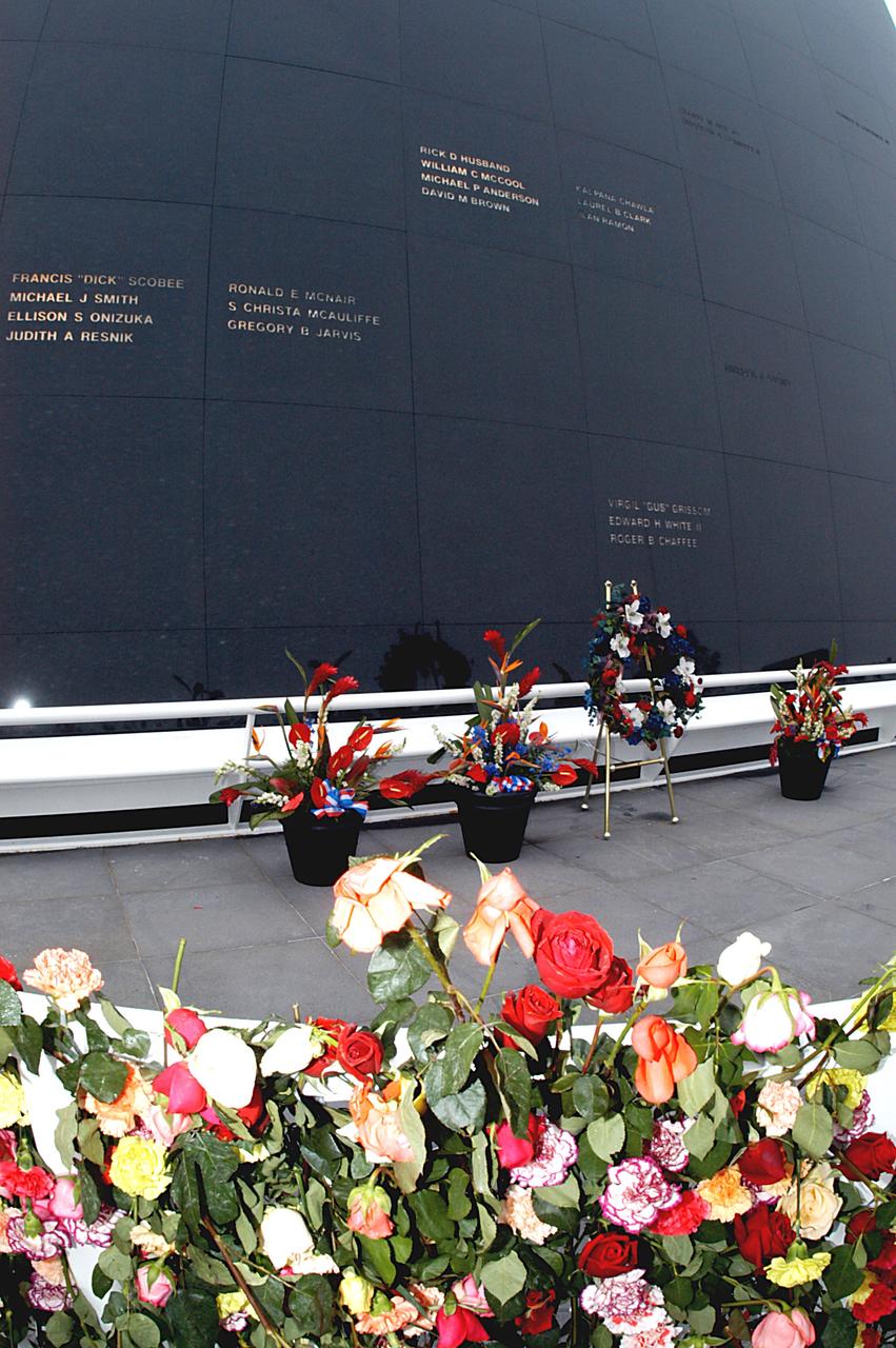 KENNEDY SPACE CENTER, FLA. - A wreath and other floral arrangements rest beneath the Astronaut Memorial Mirror at the KSC Visitor Complex following a memorial service held for the crew of Columbia on the anniversary of the tragic accident that took their lives Feb. 1, 2003.  In the foreground are a portion of the roses and carnations left by visitors who attended the memorial.  The service included comments by Center Director Jim Kennedy, Deputy Director Woodrow Whitlow Jr., Executive Director of Florida Space Authority Winston Scott, and Dr. Stephen Feldman, president of the Astronaut Memorial Foundation, who placed the wreath at the mirror.  The black granite mirror honors astronauts, whose names are carved in the surface, who have given their lives for space exploration.
