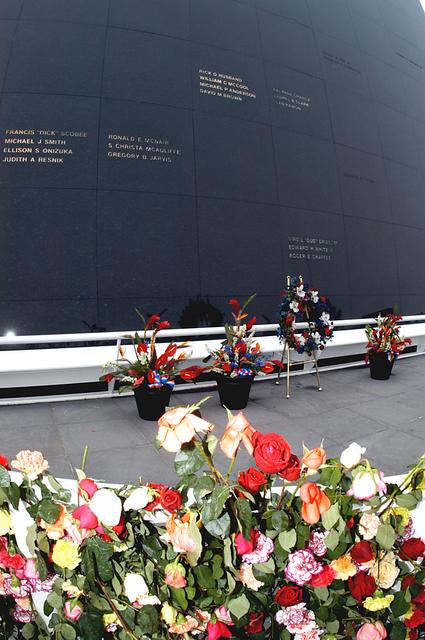 NASA image: KENNEDY SPACE CENTER, FLA. - A wreath and other floral arrangements rest beneath the Astronaut Memorial Mirror at the KSC Visitor Complex following a memorial service held for the crew of Columbia on the anniversary of the tragic accident that took their lives Feb. 1, 2003.  In the foreground are a portion of the roses and carnations left by visitors who attended the memorial.  The service included comments by Center Director Jim Kennedy, Deputy Director Woodrow Whitlow Jr., Executive Director of Florida Space Authority Winston Scott, and Dr. Stephen Feldman, president of the Astronaut Memorial Foundation, who placed the wreath at the mirror.  The black granite mirror honors astronauts, whose names are carved in the surface, who have given their lives for space exploration.