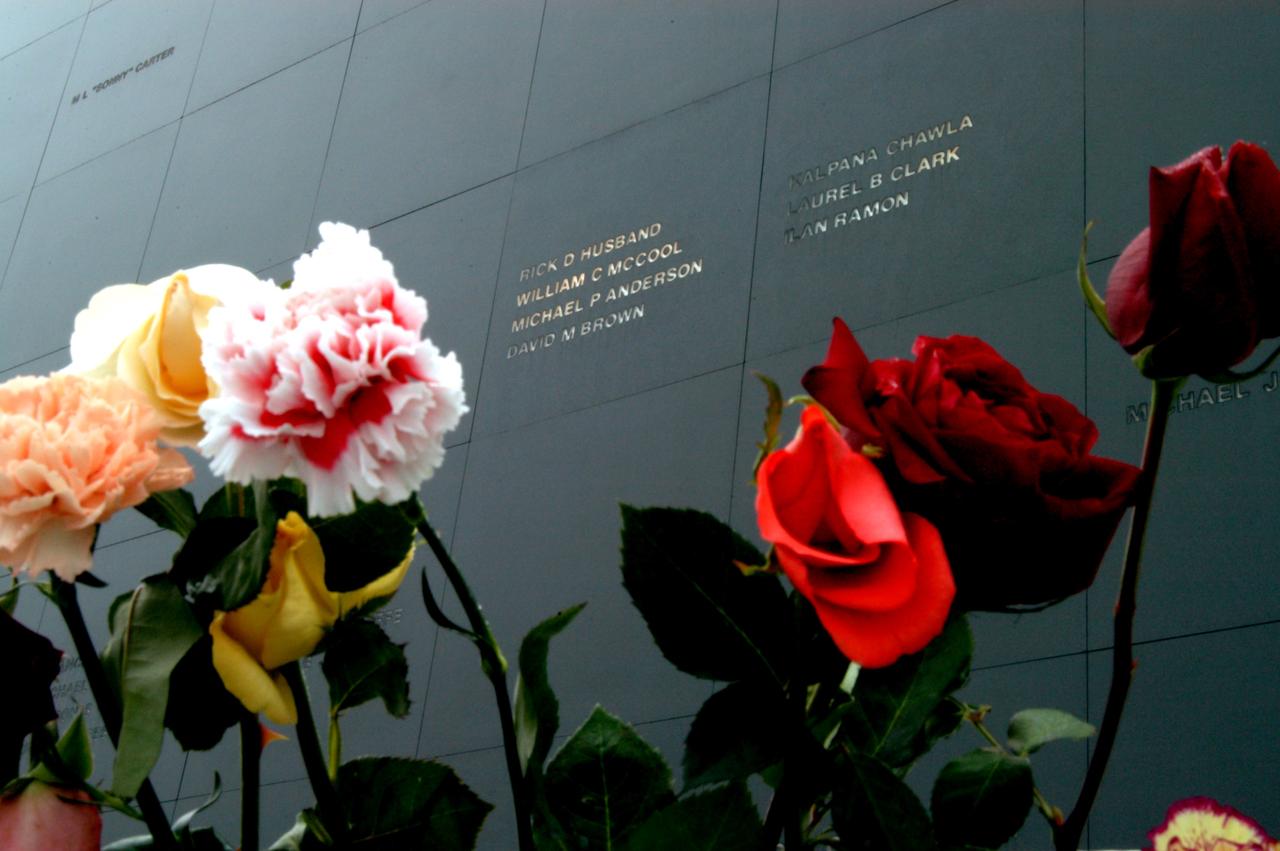 KENNEDY SPACE CENTER, FLA. - Brilliant roses and carnations frame the names of the Columbia crew carved onto the black granite surface of the Astronaut Memorial Mirror at the KSC Visitor Complex.  The flowers were left by visitors who attended a memorial service for the crew on the anniversary of the tragic accident that claimed their lives Feb. 1, 2003.  The service included comments by Center Director Jim Kennedy, Deputy Director Woodrow Whitlow Jr., Executive Director of Florida Space Authority Winston Scott, and Dr. Stephen Feldman, president of the Astronaut Memorial Foundation, who placed the wreath at the mirror.  The mirror honors astronauts who have given their lives for space exploration.