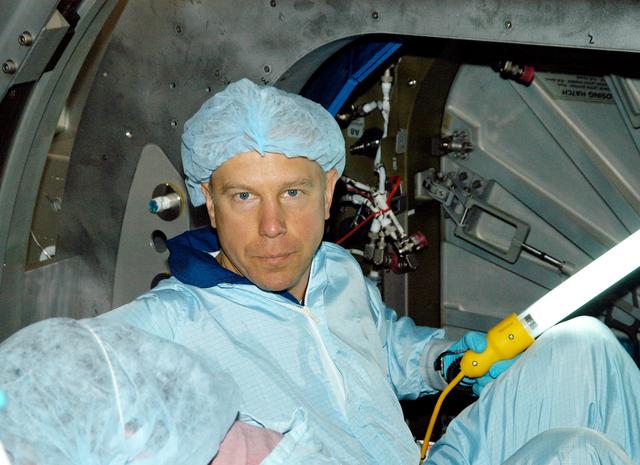 NASA image: KENNEDY SPACE CENTER, FLA. - Astronaut Tim Kopra talks to a technician (off-camera) during Intravehicular Activity (IVA) constraints testing on the Italian-built Node 2, a future element of the International Space Station.  The second of three Station connecting modules, the Node 2 attaches to the end of the U.S. Lab and provides attach locations for several other elements.  Kopra is currently assigned technical duties in the Space Station Branch of the Astronaut Office, where his primary focus involves the testing of crew interfaces for two future ISS modules as well as the implementation of support computers and operational Local Area Network on ISS.   Node 2 is scheduled to launch on mission STS-120, Station assembly flight 10A.
