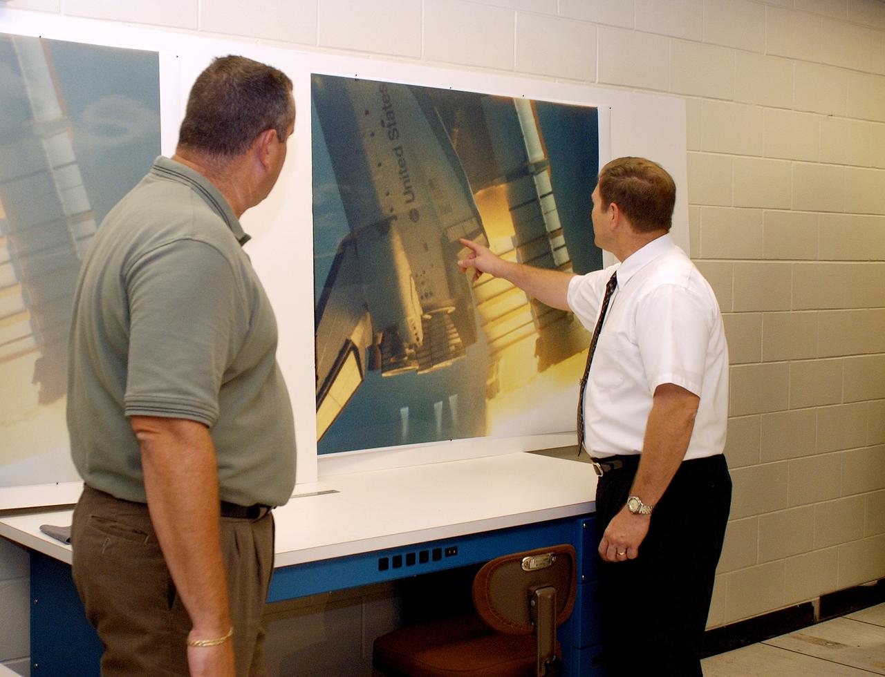 KENNEDY SPACE CENTER, FLA. - One of the world’s highest performing visual film analysis systems, developed to review and analyze previous shuttle flight data (shown here) in preparation for the shuttle fleet’s return to flight, is being used today for another purpose.  NASA has permitted its use in helping to analyze a film that shows a recent kidnapping in progress in Florida.  The system, developed by NASA, United Space Alliance (USA) and Silicon Graphics Inc., allows multiple-person collaboration,  highly detailed manipulation and evaluation of specific imagery.  The system is housed in the Image Analysis Facility inside the Vehicle Assembly Building. [Photo taken Aug. 15, 2003, courtesy of Terry Wallace, SGI ]