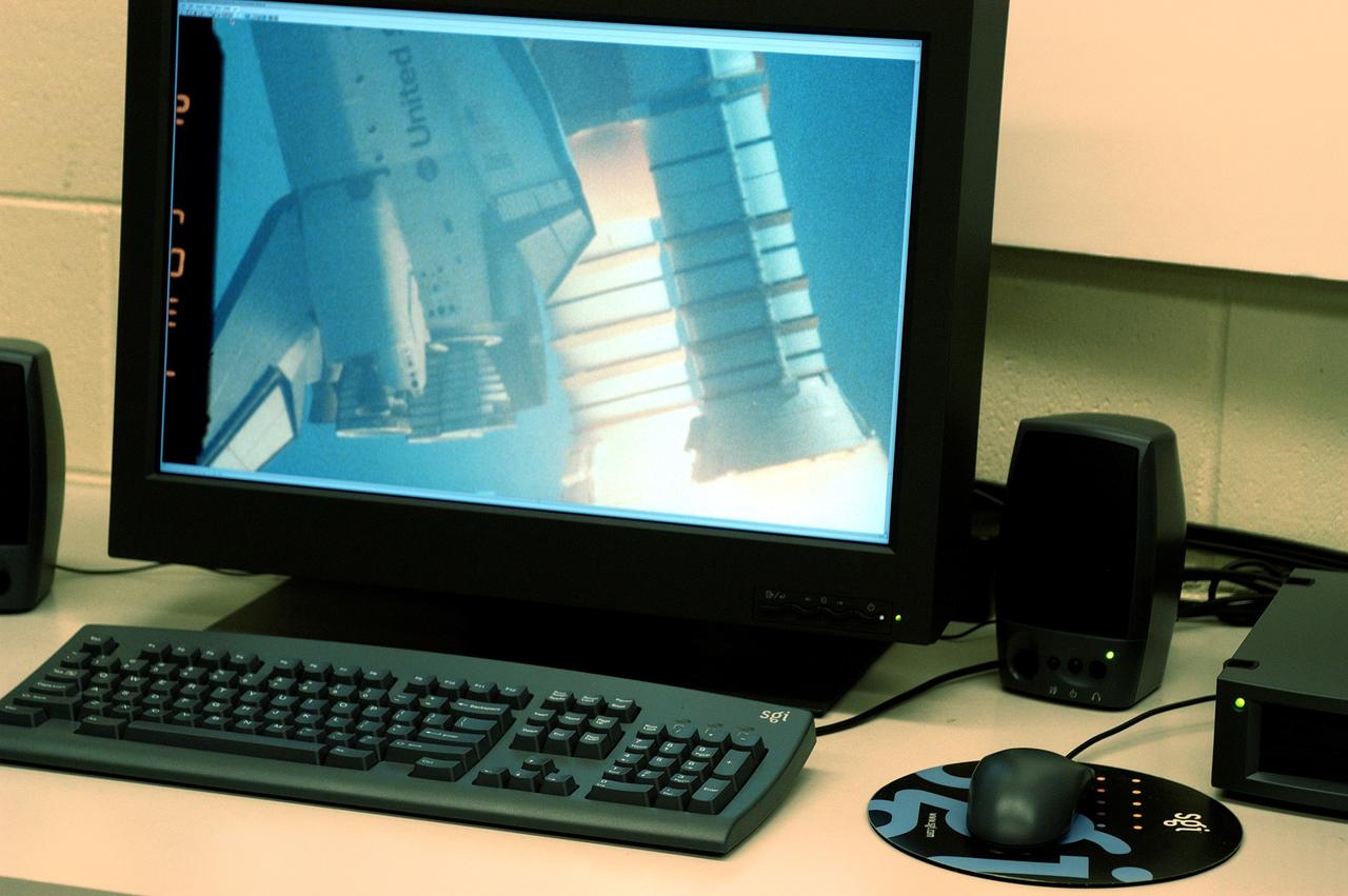KENNEDY SPACE CENTER, FLA. - One of the world’s highest performing visual film analysis systems, developed to review and analyze previous shuttle flight data (shown here) in preparation for the shuttle fleet’s return to flight, is being used today for another purpose.  NASA has permitted its use in helping to analyze a film that shows a recent kidnapping in progress in Florida.  The system, developed by NASA, United Space Alliance (USA) and Silicon Graphics Inc., allows multiple-person collaboration,  highly detailed manipulation and evaluation of specific imagery.  The system is housed in the Image Analysis Facility inside the Vehicle Assembly Building. [Photo taken Aug. 15, 2003, courtesy of Terry Wallace, SGI ]