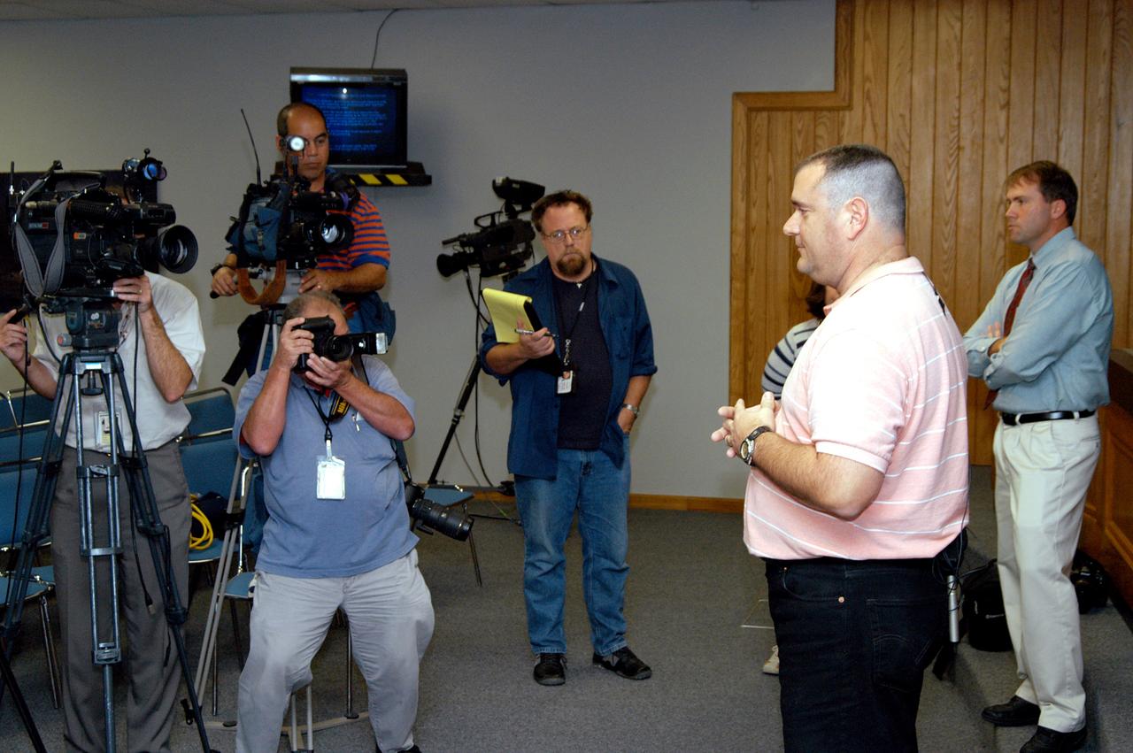 KENNEDY SPACE CENTER, FLA. - Armando Oliu, Final Inspection Team lead for the Shuttle program, speaks to reporters about the aid the Image Analysis Lab is giving the FBI in a kidnapping case. Behind him at right is Mike Rein, External Affairs division chief. Oliu oversees the image lab that is using an advanced SGI® TP9500 data management system to review the tape of the kidnapping in progress in Sarasota, Fla. KSC installed the new $3.2 million system in preparation for Return to Flight of the Space Shuttle fleet. The lab is studying the Sarasota kidnapping video to provide any new information possible to law enforcement officers. KSC is joining NASA’s Marshall Space Flight Center in Alabama in reviewing the tape.