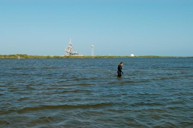 NASA image: KENNEDY SPACE CENTER, FLA. - Karen Holloway-Adkins, KSC wildlife specialist, searches the Banana River for a grass specimen. In the background is one of the launch pads.  The biologist is studying the life history of sea turtles, especially what they eat, where they lay their eggs and what factors might harm their survival.  On the boat trip she is also monitoring the growth of sea grasses and algae and the water quality of estuaries and lagoons used by sea turtles and other aquatic wildlife.
