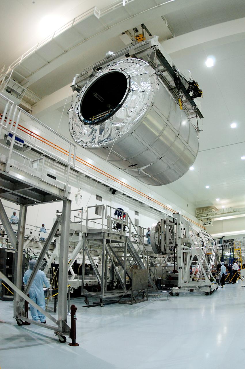 KENNEDY SPACE CENTER, FLA. - A worker on the floor watches as the Multi-Purpose Logistics Module Raffaello moves toward another work stand in the Space Station Processing Facility.  Raffaello is the second MPLM built by the Italian Space Agency, serving as a reusable logistics carrier and primary delivery system to resupply and return station cargo requiring a pressurized environment.  It has been moved across the floor to allow the third MPLM, Donatello, to be brought in for routine testing.  Donatello has been stored in the Operations and Checkout Building.  This is the first time all three MPLMs are in the SSPF; the other one is the Leonardo.  Raffaello is scheduled to fly on Space Shuttle Atlantis on mission STS-114.