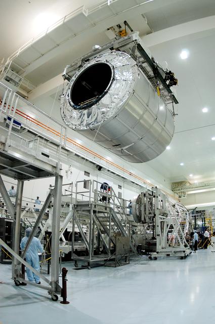 NASA image: KENNEDY SPACE CENTER, FLA. - A worker on the floor watches as the Multi-Purpose Logistics Module Raffaello moves toward another work stand in the Space Station Processing Facility.  Raffaello is the second MPLM built by the Italian Space Agency, serving as a reusable logistics carrier and primary delivery system to resupply and return station cargo requiring a pressurized environment.  It has been moved across the floor to allow the third MPLM, Donatello, to be brought in for routine testing.  Donatello has been stored in the Operations and Checkout Building.  This is the first time all three MPLMs are in the SSPF; the other one is the Leonardo.  Raffaello is scheduled to fly on Space Shuttle Atlantis on mission STS-114.