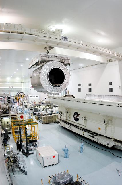 KENNEDY SPACE CENTER, FLA. - Overhead cables carry the Multi-Purpose Logistics Module Donatello from the payload canister (lower right) to a work stand in the Space Station Processing Facility.  Previously housed in the Operations and Checkout Building, Donatello was brought into the SSPF for routine testing.  This is the first time all three MPLMs (Donatello, Raffaello and Leonardo) are in the SSPF.  The MPLMs were built by the Italian Space Agency, to serve as reusable logistics carriers and the primary delivery system to resupply and return station cargo requiring a pressurized environment.  The third MPLM, Raffaello is scheduled to fly on Space Shuttle Atlantis on mission STS-114.
