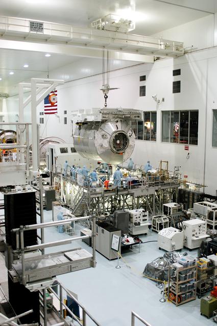 NASA image: KENNEDY SPACE CENTER, FLA. - In the Space Station Processing Facility,  the Multi-Purpose Logistics Module Donatello is slowly lowered toward a work stand.  Previously housed in the Operations and Checkout Building, Donatello was brought into the SSPF for routine testing.  This is the first time all three MPLMs (Donatello, Raffaello and Leonardo) are in the SSPF.  The MPLMs were built by the Italian Space Agency, to serve as reusable logistics carriers and the primary delivery system to resupply and return station cargo requiring a pressurized environment.  The third MPLM, Raffaello is scheduled to fly on Space Shuttle Atlantis on mission STS-114.