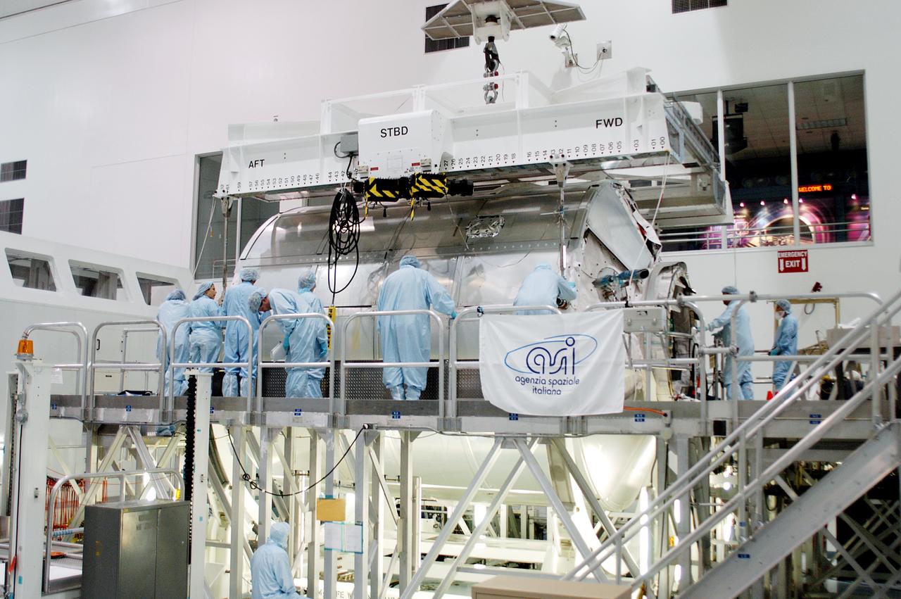 KENNEDY SPACE CENTER, FLA. - In the Space Station Processing Facility,  workers confirm the Multi-Purpose Logistics Module Donatello is safely in place on a work stand.  Previously housed in the Operations and Checkout Building, Donatello was brought into the SSPF for routine testing.  This is the first time all three MPLMs (Donatello, Raffaello and Leonardo) are in the SSPF.  The MPLMs were built by the Italian Space Agency, to serve as reusable logistics carriers and the primary delivery system to resupply and return station cargo requiring a pressurized environment.  The third MPLM, Raffaello, is scheduled to fly on Space Shuttle Atlantis on mission STS-114.