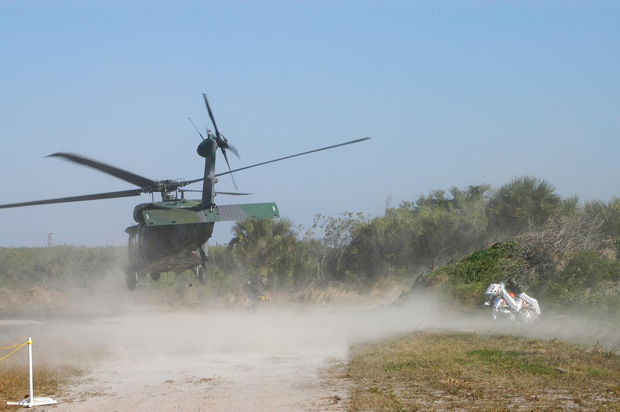 KENNEDY SPACE CENTER, FLA. - A helicopter is landing near rescue team members taking part in a “Mode VII” emergency landing simulation at Kennedy Space Center.  The purpose of Mode VII is to exercise emergency preparedness personnel, equipment and facilities in rescuing astronauts from a downed orbiter and providing immediate medical attention.  This simulation presents an orbiter that has crashed short of the Shuttle Landing Facility in a wooded area 2-1/2 miles south of Runway 33.  Emergency crews are responding to the volunteer “astronauts” simulating various injuries inside an orbiter crew compartment mock-up.  Rescuers must remove the crew, provide triage and transport to hospitals those who need further treatment.  Local hospitals are participating in the exercise.