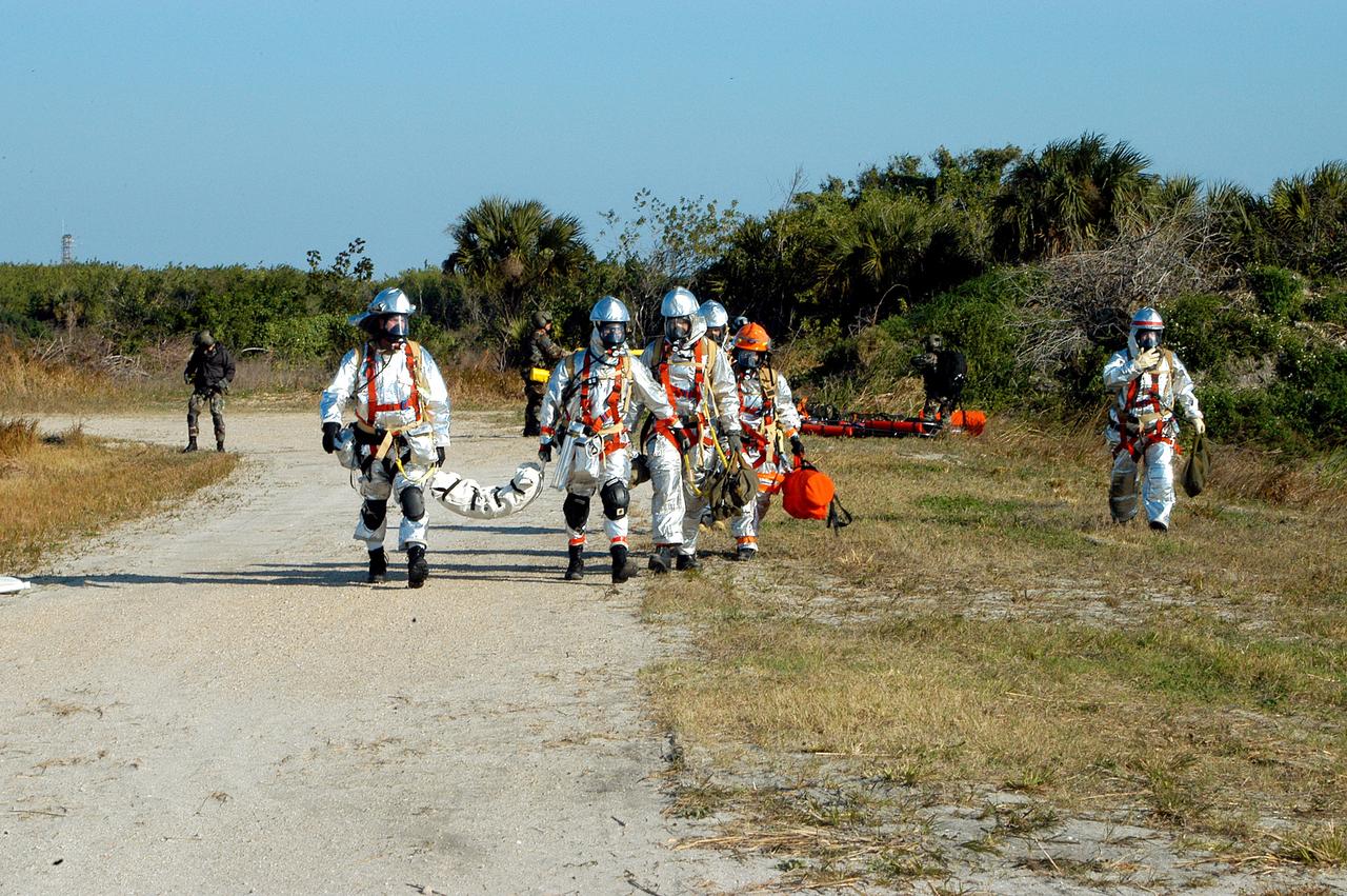KENNEDY SPACE CENTER, FLA. - Emergency crews leave the scene after a helicopter removed “rescued” astronauts from the scene.  They are taking part in a “Mode VII” emergency landing simulation at Kennedy Space Center, in order to exercise emergency preparedness personnel, equipment and facilities in rescuing astronauts from a downed orbiter and providing immediate medical attention.  This simulation presents an orbiter that has crashed short of the Shuttle Landing Facility in a wooded area 2-1/2 miles south of Runway 33.  Emergency crews are responding to the volunteer “astronauts” simulating various injuries inside an orbiter crew compartment mock-up.  Rescuers must remove the crew, provide triage and transport to hospitals those who need further treatment.  Local hospitals are participating in the exercise.