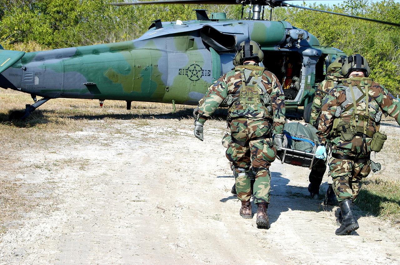 KENNEDY SPACE CENTER, FLA. - A rescue team carries an “injured” astronaut toward the helicopter for transportation to a local hospital.  They are all taking part in a “Mode VII” emergency landing simulation at Kennedy Space Center.  The purpose of the Mode VII is to exercise emergency preparedness personnel, equipment and facilities in rescuing astronauts from a downed orbiter and providing immediate medical attention.  This simulation presents an orbiter that has crashed short of the Shuttle Landing Facility in a wooded area 2-1/2 miles south of Runway 33.  Emergency crews are responding to the volunteer astronauts who are simulating various injuries inside the crew compartment mock-up.  Rescuers must remove the crew, provide triage and transport to hospitals those who need further treatment.  Local hospitals are participating in the exercise. Emergency crews are responding to the volunteer astronauts who are simulating various injuries inside the crew compartment mock-up.  Rescuers must remove the crew, provide triage and transport to hospitals those who need further treatment.  Local hospitals are participating in the exercise.