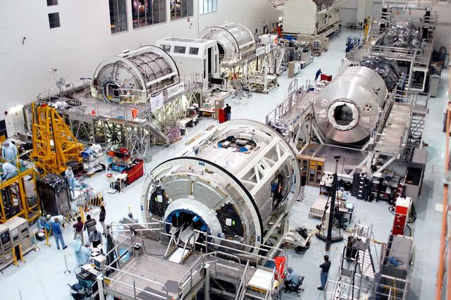 NASA image: KENNEDY SPACE CENTER, FLA. - All three Multi-Purpose Logistics Modules are on the floor of the Space Station Processing Facility.  This is the first time the three - Leonardo, Raffaello and Donatello -- have been in one location.  Donatello has been stored in the Operations and Checkout Building since its arrival at KSC and was brought into the SSPF for routine testing. The MPLMs were built by the Italian Space Agency, to serve as reusable logistics carriers and the primary delivery system to resupply and return station cargo requiring a pressurized environment.  Raffaello is scheduled to fly on Space Shuttle Atlantis on mission STS-114.