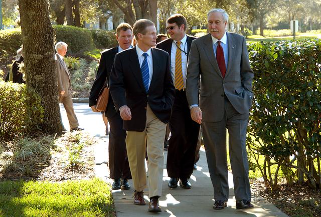 NASA image: KENNEDY SPACE CENTER, FLA. - U.S. Senator Bill Nelson (left front) and NASA Administrator Sean O’Keefe (right front) leave the Central Florida Research Park, near Orlando.  Behind Nelson (at left) is Congressman Tom Feeney.  The research park is being proposed as the location for NASA’s new Shared Services Center. Six sites around the U.S. are under consideration for location of the Center, which would centralize NASA’s payroll, accounting, human resources, facilities and procurement offices that are now handled at each field center.  The consolidation is part of the One NASA focus.  Others attending the presentation included U.S. Representative Ric Keller, Congressman Dave Weldon, Center Director Jim Kennedy and Pamella J. Dana, Ph.D., director, Office of Tourism, Trade, and Economic Development in Florida.