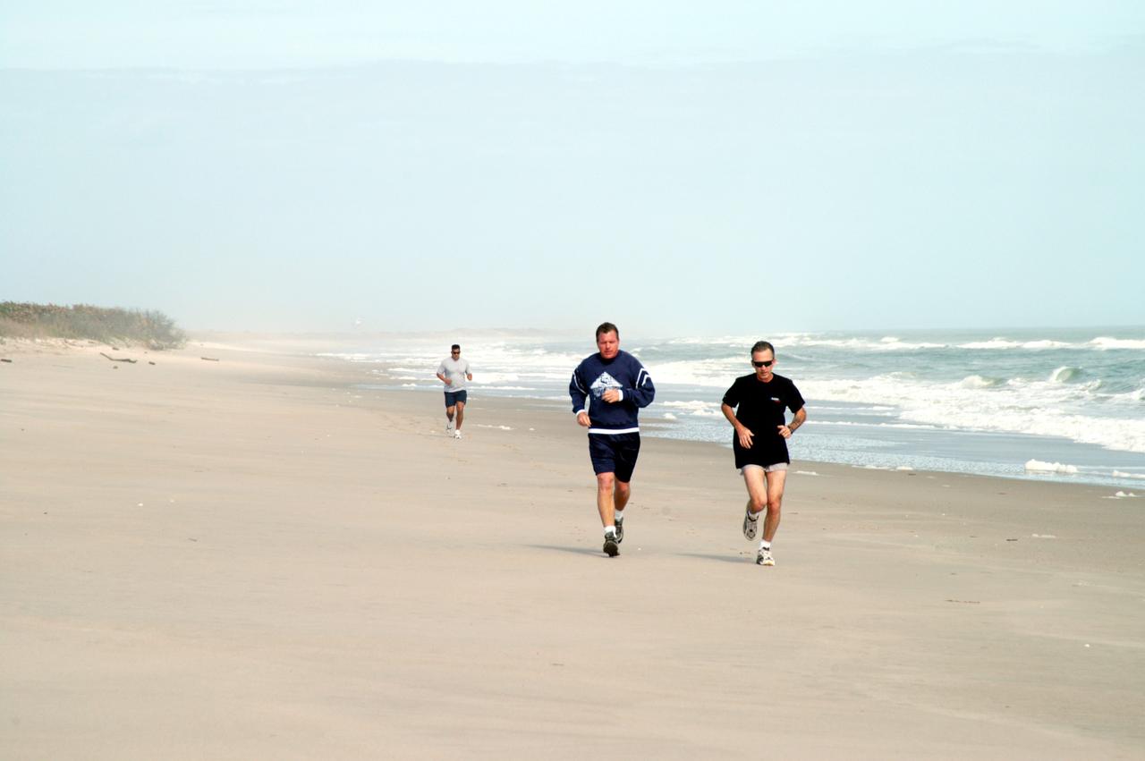 KENNEDY SPACE CENTER, FLA. - Congressman Tom Feeney (left) jogs along the beach at Kennedy Space Center.  Accompanying him is Ricky D. O’Quinn, a member of the KSC SWAT team. Behind them is Ivan Osores, with Security.  During January and February, Congressman Feeney traveled the entire coastline of Florida’s 24th District, and concluded his walks March 1 in Brevard County.  On his walks, he met with constituents and community leaders to discuss legislative issues that will be addressed by the 108th Congress.
