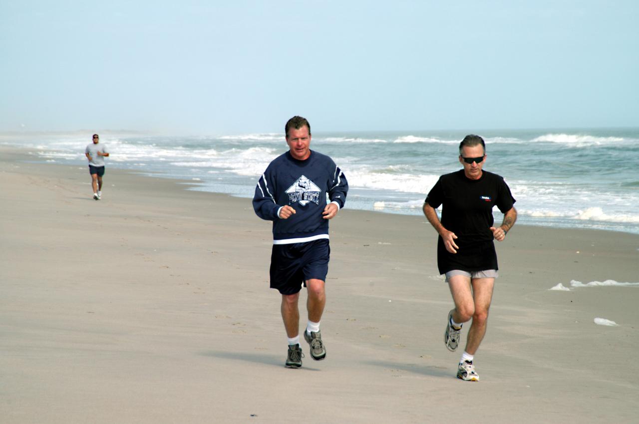 KENNEDY SPACE CENTER, FLA. - Congressman Tom Feeney (left) jogs along the beach at Kennedy Space Center.  Accompanying him is Ricky D. O’Quinn, a member of the KSC SWAT team. In the background is Ivan Osores, with Security.  During January and February, Congressman Feeney traveled the entire coastline of Florida’s 24th District, and concluded his walks March 1 in Brevard County.  On his walks, he met with constituents and community leaders to discuss legislative issues that will be addressed by the 108th Congress.