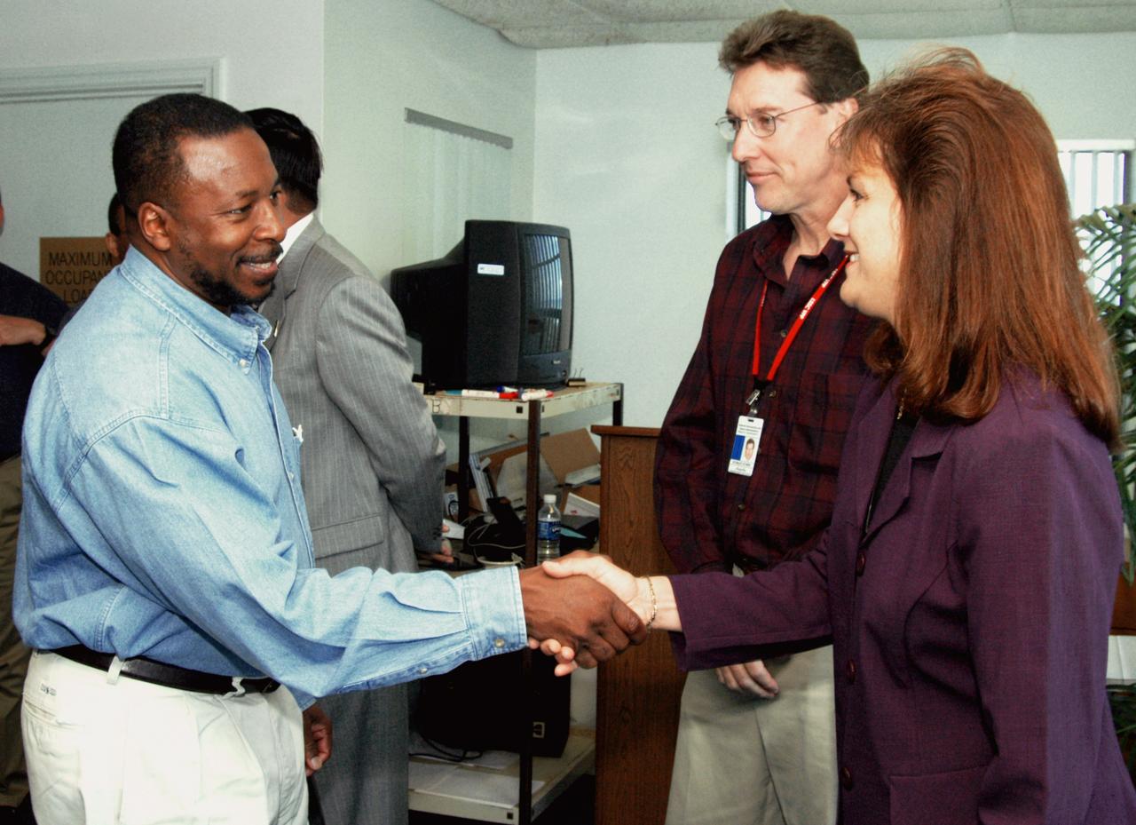 KENNEDY SPACE CENTER, FLA. - At the Beach House, Deputy Director Woodrow Whitlow Jr. greets Ellen Feeney, wife of Congressman Tom Feeney.  Between them is Stan Starr, with Dynamac Corp.  During January and February, Congressman Feeney traveled the entire coastline of Florida’s 24th District, and concluded his walks March 1 in Brevard County.  On his walks, he met with constituents and community leaders to discuss legislative issues that will be addressed by the 108th Congress.