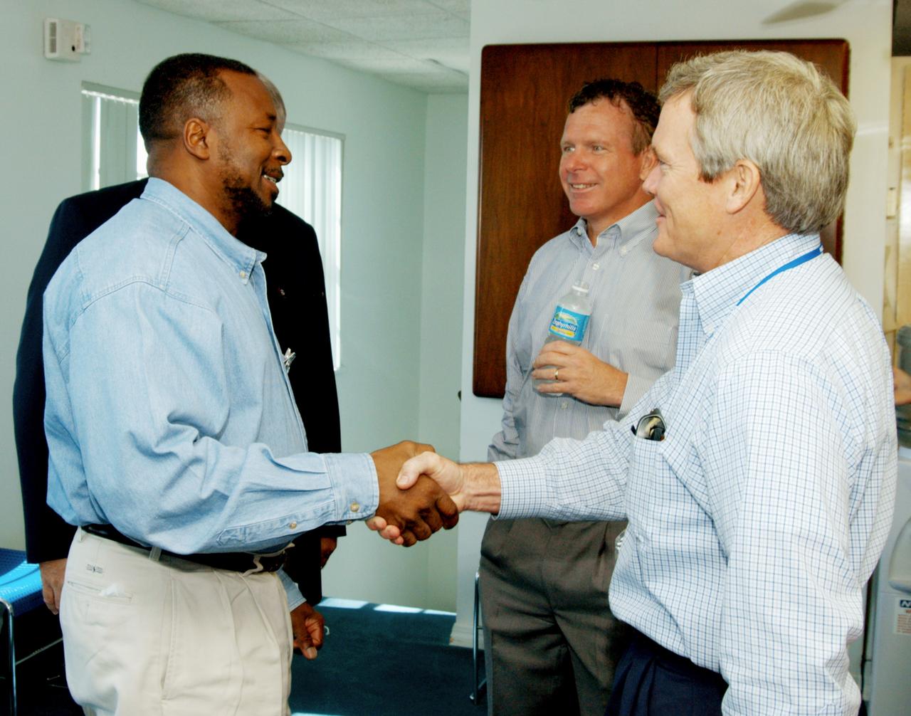 KENNEDY SPACE CENTER, FLA. - At the Beach House, Deputy Director Woodrow Whitlow Jr. (left) greets Bruce Melnick (right), vice president for Boeing Florida Operations at KSC. In the background is Congressman Tom Feeney. During January and February, Congressman Feeney traveled the entire coastline of Florida’s 24th District, and concluded his walks March 1 in Brevard County. On the walks, he met with constituents and community leaders to discuss legislative issues that will be addressed by the 108th Congress.