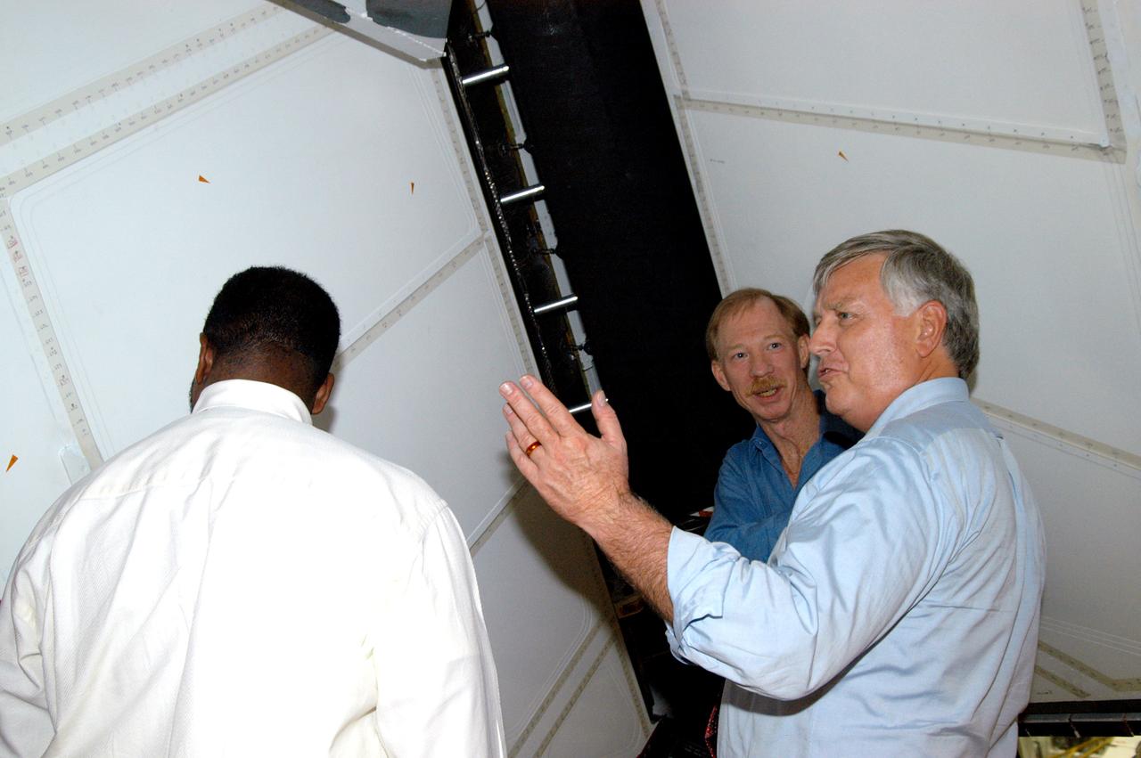 KENNEDY SPACE CENTER, FLA. - On a tour of the Orbiter Processing Facility, Center Director Jim Kennedy (right) and Deputy Director Woodrow Whitlow Jr. (center) look at the rudder speed brake panels on the orbiter Endeavour.  In the background is Tom Roberts, who is with United Space Alliance.  Endeavour is in its Orbiter Major Modification period, which began in December 2003.