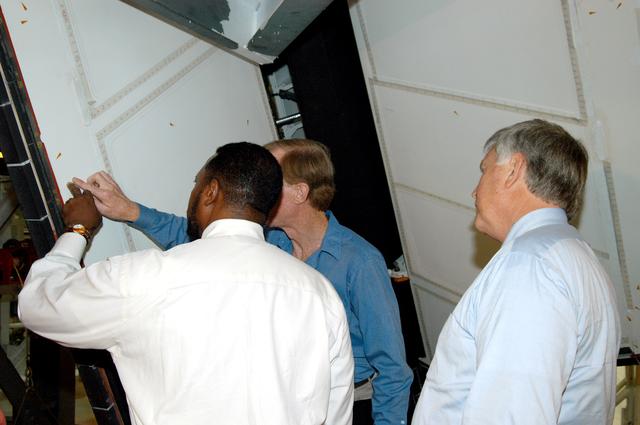NASA image: KENNEDY SPACE CENTER, FLA. - On a tour of the Orbiter Processing Facility, Deputy Director Woodrow Whitlow Jr. points to an area on a rudder speed brake panel on Endeavour that Tom Roberts, who is with United Space Alliance, is showing him.  At right is Center Director Jim Kennedy.  Endeavour is in its Orbiter Major Modification period, which began in December 2003.