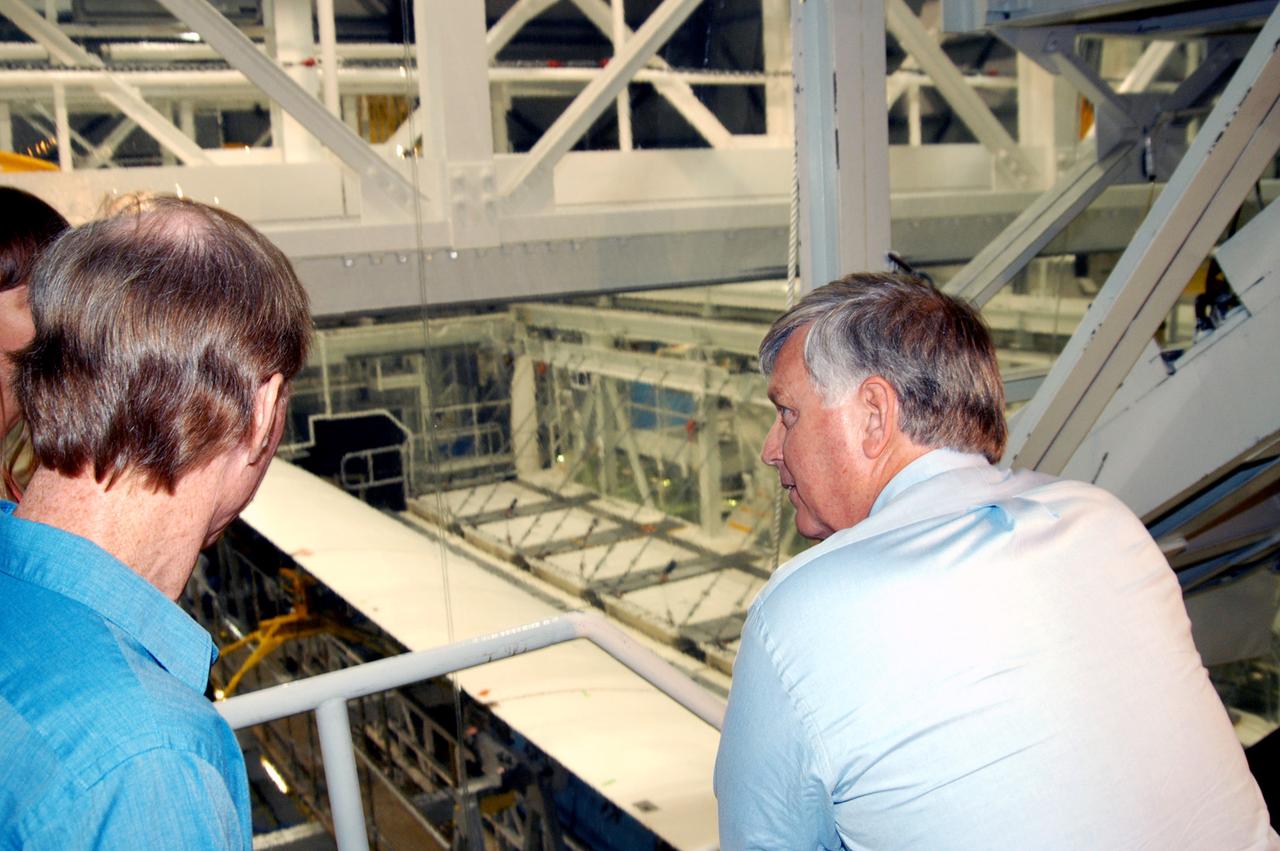 KENNEDY SPACE CENTER, FLA. - On a tour of the Orbiter Processing Facility, Center Director Jim Kennedy (right) looks over some of the work being done on the orbiter Endeavour.  At left is Tom Roberts, who is with United Space Alliance.  Endeavour is in its Orbiter Major Modification period, which began in December 2003.