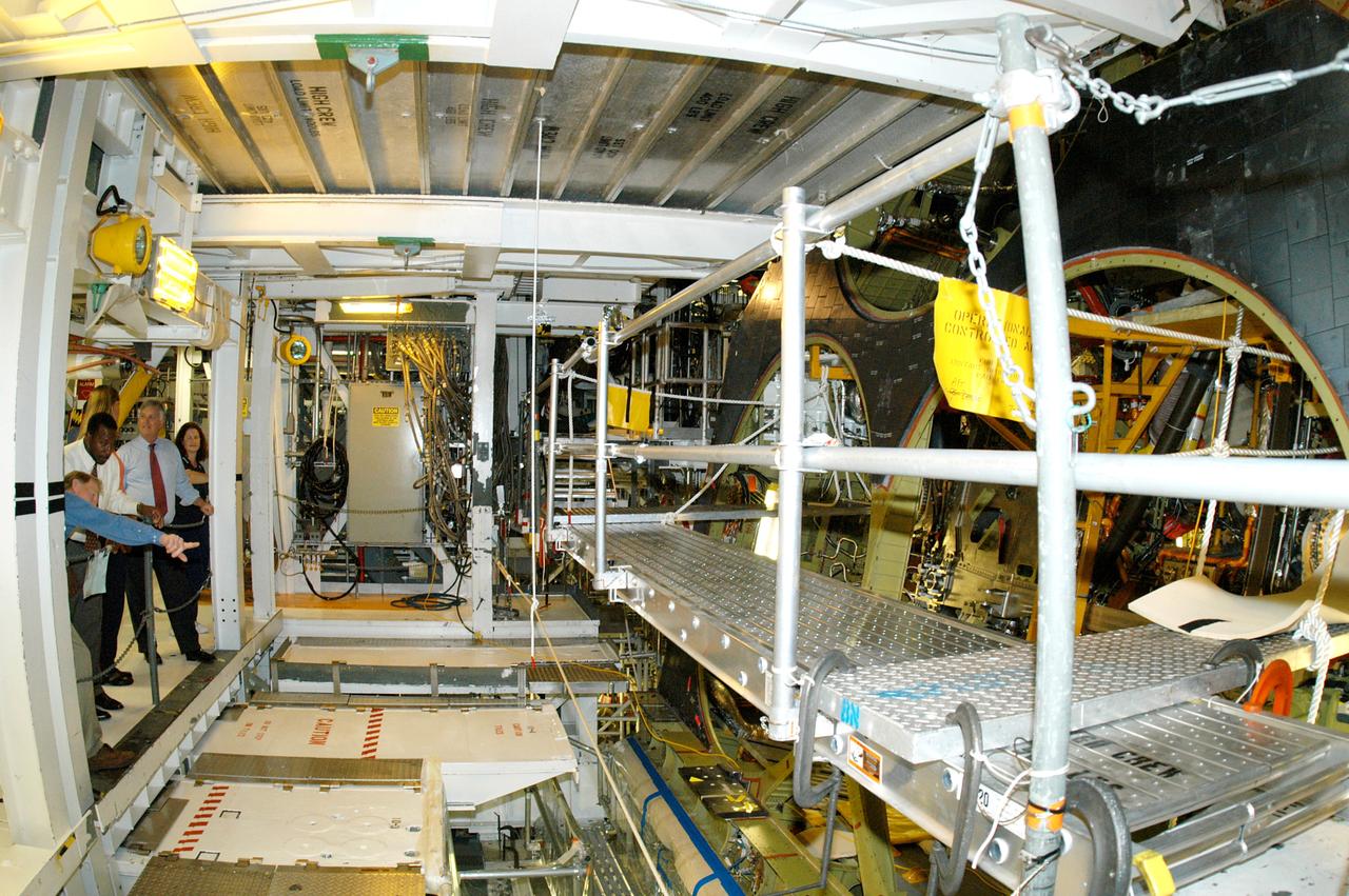 KENNEDY SPACE CENTER, FLA. - On a tour of the Orbiter Processing Facility, Center Director Jim Kennedy and Deputy Director Woodrow Whitlow Jr. (both at left) look over some of the work being done on the orbiter Endeavour that Tom Roberts, with United Space Alliance, is pointing out.  Endeavour is in its Orbiter Major Modification period, which began in December 2003.