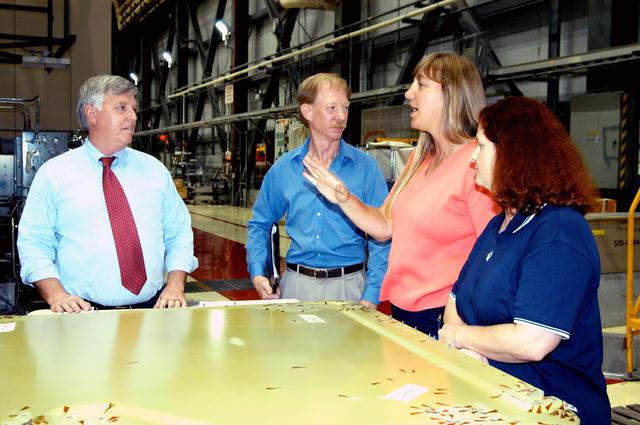 KENNEDY SPACE CENTER, FLA. - On a tour of the Orbiter Processing Facility, Center Director Jim Kennedy (left) listens to Kathy Laufenberg, Orbiter Airframe Engineering ground area manager, with United Space Alliance, about corrosion work being done on the external tank door of orbiter Endeavour. On either side of Laufenberg are Tom Roberts, Airframe Engineering System specialist, also with USA, and Joy Huff, with KSC Space Shuttle Processing.  Endeavour is in its Orbiter Major Modification period, which began in December 2003.