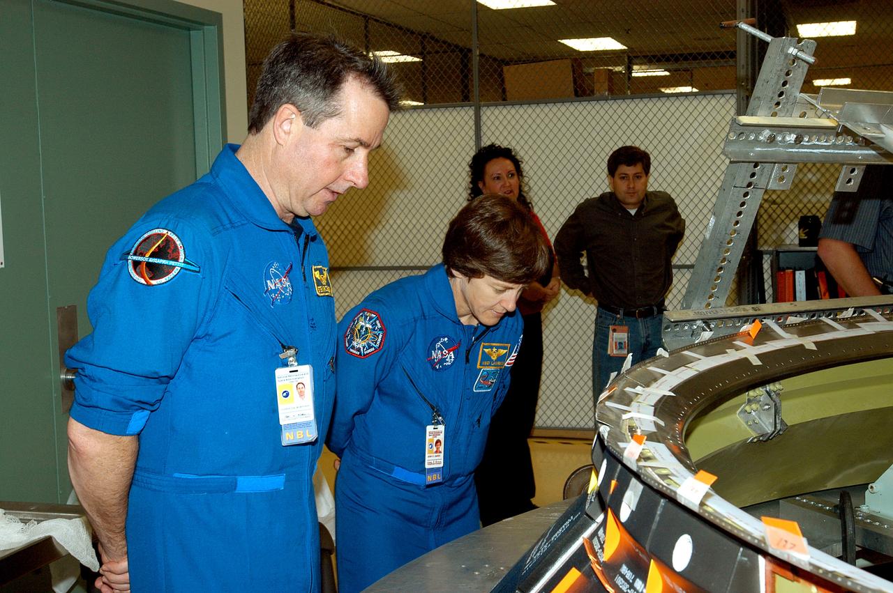 KENNEDY SPACE CENTER, FLA. -  Members of the STS-114 crew spend time in the Orbiter Processing Facility becoming familiar with Shuttle and mission equipment.  Mission Specialists Stephen Robinson (left) and Wendy Lawrence (right) look at an engine eyelet, which serves as part of the thermal protection system on an orbiter.  The STS-114 mission is Logistics Flight 1, which is scheduled to deliver supplies and equipment and the external stowage platform to the International Space Station.