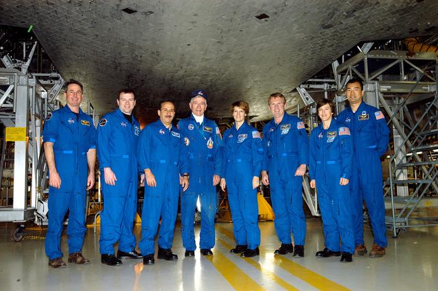 NASA image: KENNEDY SPACE CENTER, FLA. - The STS-114 crew stands underneath Discovery in the Orbiter Processing Facility.  From left are Mission Specialist Stephen Robinson, Pilot James Kelly, Mission Specialist Charles Camarda, astronaut John Young, Commander Eileen Collins and Mission Specialists Andrew Thomas, Wendy Lawrence and Soichi Noguchi, who is with the Japanese Aerospace and Exploration Agency.  Young is associate director, Technical, at Johnson Space Center. The crew is spending time becoming familiar with Shuttle and mission equipment. The mission is Logistics Flight 1, which is scheduled to deliver supplies and equipment plus the external stowage platform to the International Space Station.