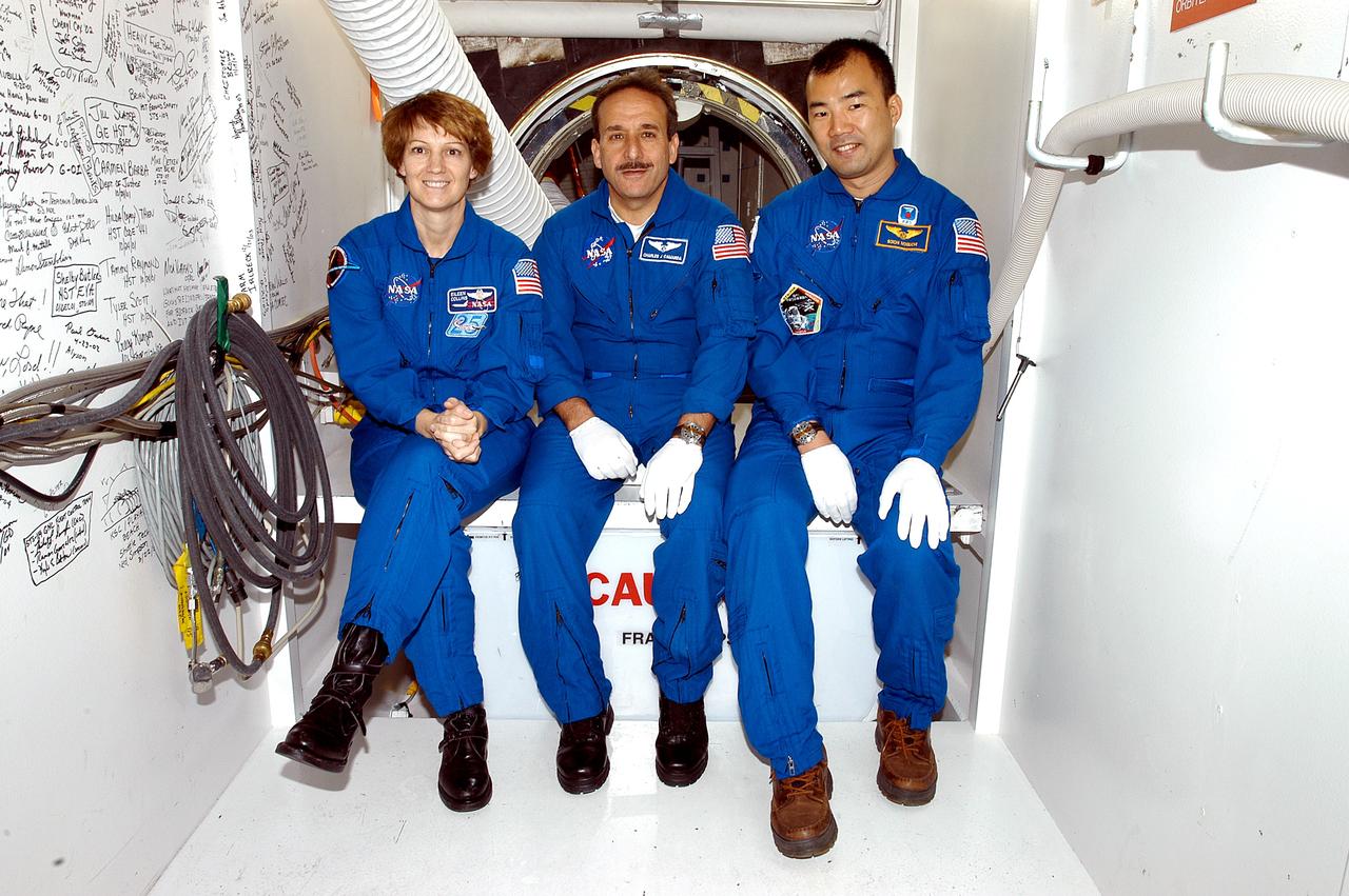 KENNEDY SPACE CENTER, FLA. - STS-114 Commander Eileen Collins and Mission Specialists Charles Camarda and Soichi Noguchi sit outside the crew hatch on the orbiter Discovery.  Noguchi is with the Japanese Aerospace and Exploration Agency.   They and other crew members are at KSC becoming familiar with Shuttle and mission equipment. The mission is Logistics Flight 1, which is scheduled to deliver supplies and equipment plus the external stowage platform to the International Space Station.