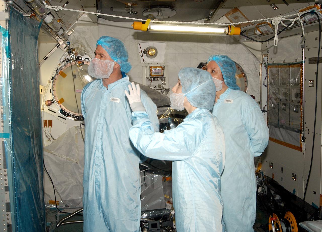 KENNEDY SPACE CENTER, FLA. - - In the Space Station Processing Facility, STS-114 Mission Specialist Stephen Robinson (left) learns about the Japanese Experiment Module (JEM) from Jennifer Goldsmith (center), with United Space Alliance at Johnson Space Center, and Louise Kleba (right), with USA at KSC.  Crew members are at KSC to become familiar with Shuttle and mission equipment. The mission is Logistics Flight 1, which is scheduled to deliver supplies and equipment plus the external stowage platform to the International Space Station.