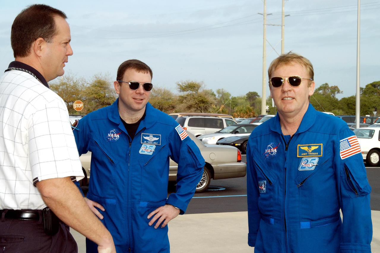 KENNEDY SPACE CENTER, FLA. - At the SRB Assembly and Refurbishment Facility, STS-114 crew members Pilot James Kelly and Mission Specialist Andrew Thomas talk with Tom Engler, Marshall Space Flight Center SRB Resident Office lead. The STS-114 crew is at KSC for familiarization with Shuttle and mission equipment. The mission is Logistics Flight 1, which is scheduled to deliver supplies and equipment, plus the external stowage platform, to the International Space Station.