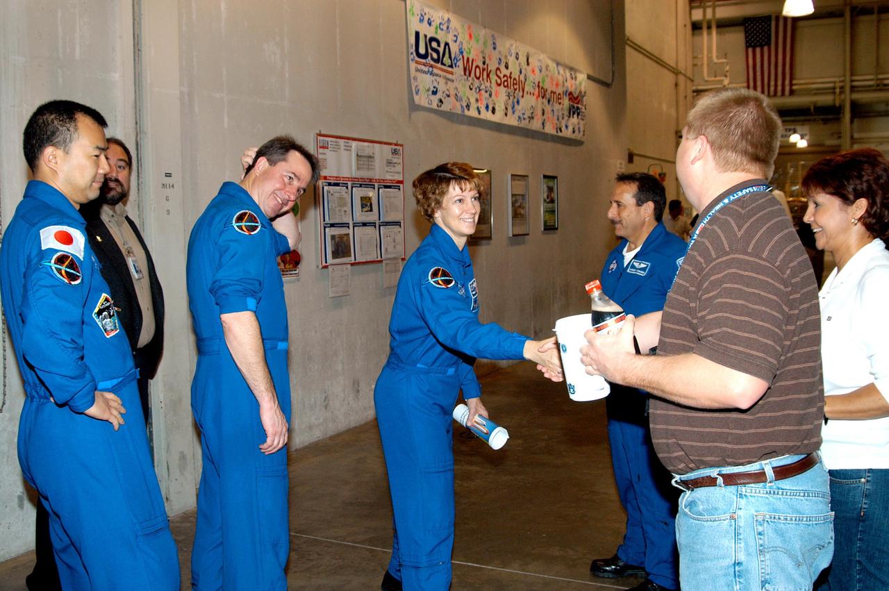 KENNEDY SPACE CENTER, FLA. -  In the SRB Assembly and Refurbishment Facility, some of the STS-114 crew greet United Space Alliance employees Ed Glovich and Noemi Navaro-Cruz.  The crew members are (from left) Mission Specialists Soichi Noguchi and Stephen Robinson; Commander Eileen Collins; and Mission Specialist Charles Camarda. Behind Noguchi, who represents the Japanese Aerospace and Exploration Agency, is Paul Gutierrez, SRB associate program manager with United Space Alliance.  The STS-114 crew is at KSC for familiarization with Shuttle and mission equipment. The STS-114 mission is Logistics Flight 1, which is scheduled to deliver supplies and equipment, plus the external stowage platform, to the International Space Station.