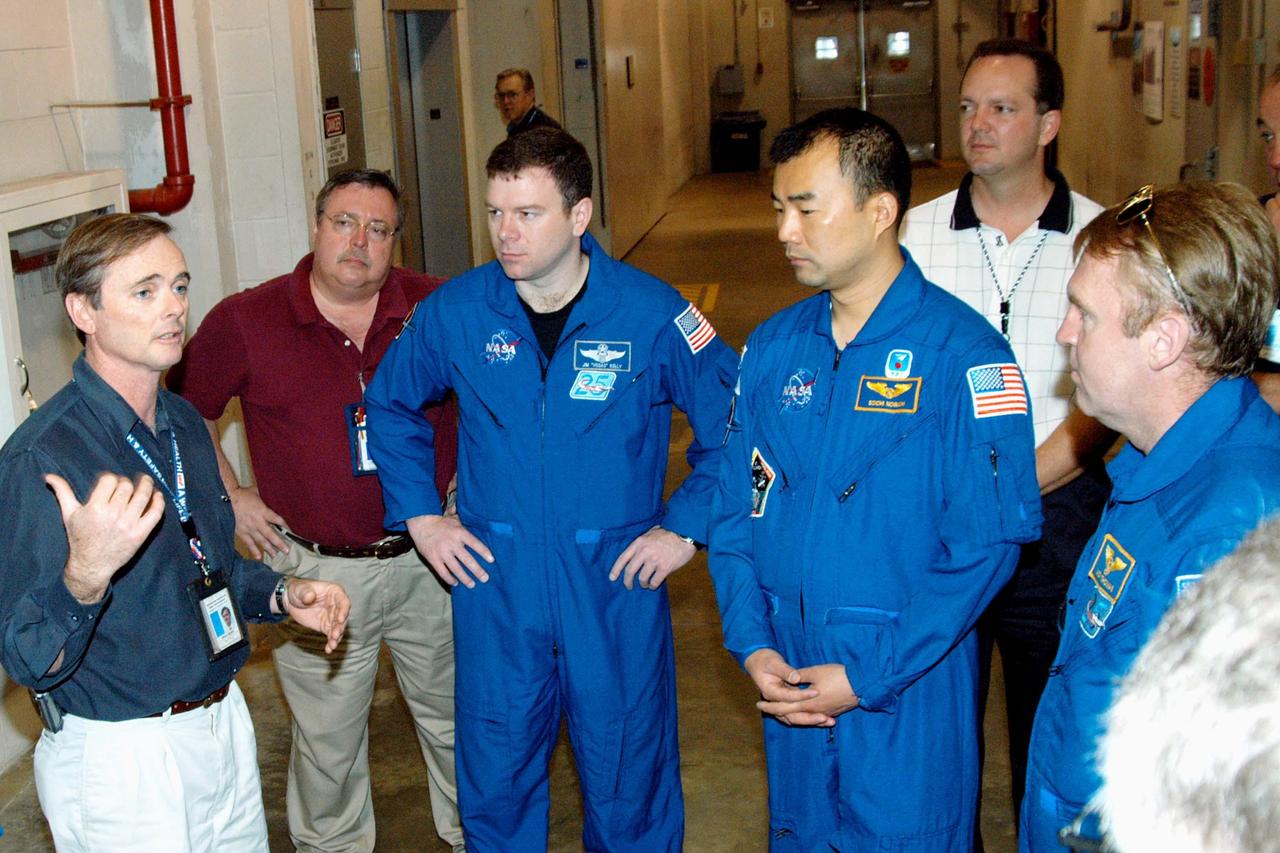 KENNEDY SPACE CENTER, FLA. - - In the SRB Assembly and Refurbishment Facility, some of the STS-114 crew listen to Greg Henry, SRB Element director of Manufacturing Operations with United Space Alliance. Crew members, from center to right, are Pilot James Kelly and Mission Specialists Soichi Noguchi and Andrew Thomas. Noguchi represents the Japanese Aerospace and Exploration Agency. In the background, at right, is Tom Engler, Marshall Space Flight Center SRB Resident Office lead. The crew is at KSC for familiarization with Shuttle and mission equipment. The STS-114 mission is Logistics Flight 1, which is scheduled to deliver supplies and equipment, plus the external stowage platform, to the International Space Station.