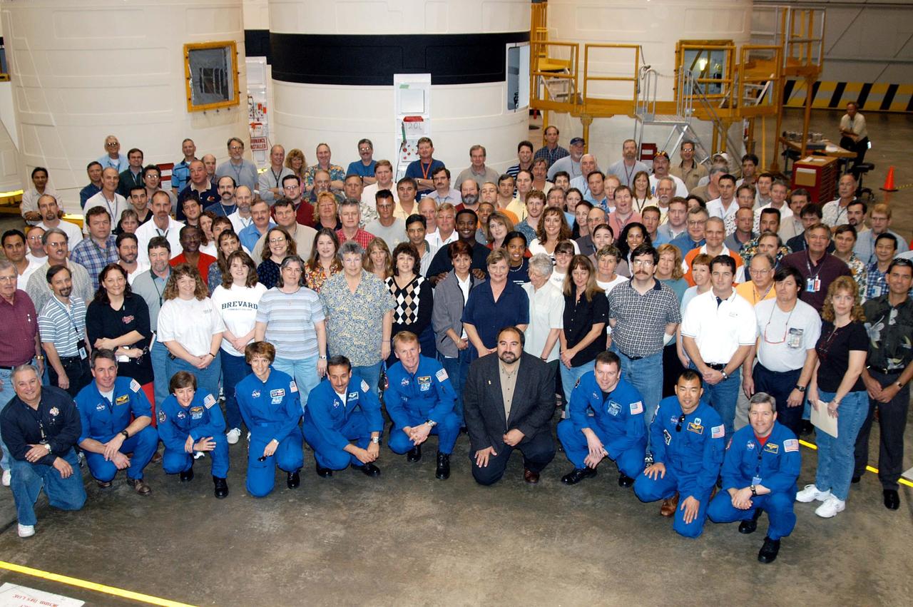 KENNEDY SPACE CENTER, FLA. -  -  The STS-114 crew poses with the employees in the SRB Assembly and Refurbishment Facility.  At far left is L. Roger Elliot, director of Design engineering for SRB Element, United Space Alliance; next are Mission Specialists Stephen Robinson and Wendy Lawrence; Commander Eileen Collins; Mission Specialists Charles Camarda and Andrew Thomas; at center is Paul Gutierrez, associate program manager in SRB Element; Pilot James Kelly; Mission Specialist Soichi Noguchi; and astronaut Steven Frick, who joined the STS-114 crew during equipment familiarization at KSC. Noguchi represents the Japanese Aerospace and Exploration Agency.  The STS-114 mission is Logistics Flight 1, which is scheduled to deliver supplies and equipment, plus the external stowage platform, to the International Space Station.