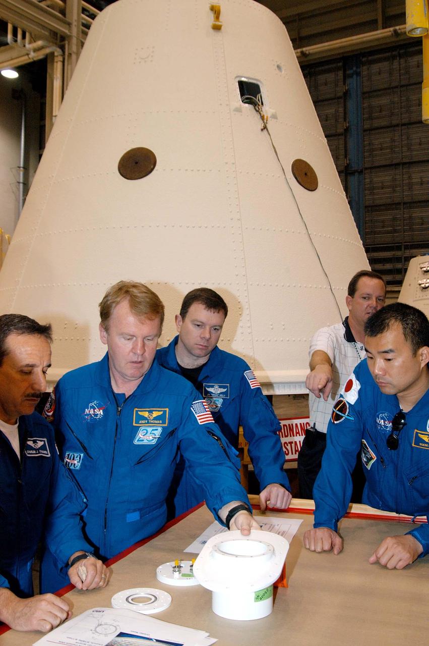 KENNEDY SPACE CENTER, FLA. - In the SRB Assembly and Refurbishment Facility, STS-114 crew members look at external tank-solid rocket booster camera components. From left are Mission Specialists Charles Camarda and Andrew Thomas, Pilot James Kelly, and Mission Specialist Soichi Noguchi, who represents the Japanese Aerospace and Exploration Agency. Behind Noguchi is Tom Engler, SRB Resident Office lead at Marshall Space Flight Center. They are standing in front of an SRB frustum. The crew is at KSC for familiarization with Shuttle and mission equipment. The STS-114 mission is Logistics Flight 1, which is scheduled to deliver supplies and equipment, plus the external stowage platform, to the International Space Station.
