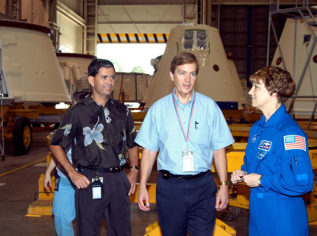 KENNEDY SPACE CENTER, FLA. - In the SRB Assembly and Refurbishment Facility, STS-114 Commander Eileen Collins talks with Bob Osterblom (left), with the Marshall Space Flight Center Resident Office, and Craig Bennett, a Defense Contract Management Agency inspector. The STS-114 crew is at KSC for familiarization with Shuttle and mission equipment. The mission is Logistics Flight 1, which is scheduled to deliver supplies and equipment, plus the external stowage platform, to the International Space Station.