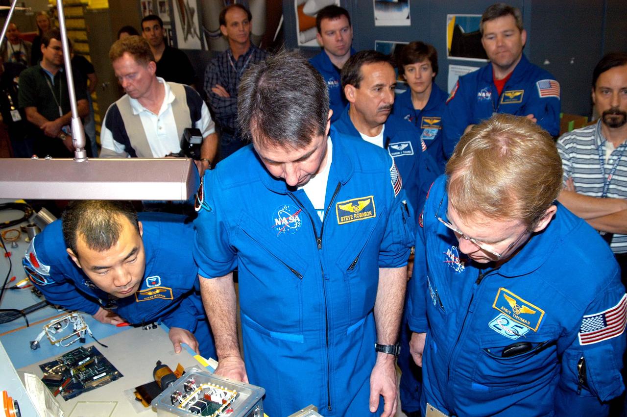 KENNEDY SPACE CENTER, FLA. -  In the electrical engineering lab of the SRB Assembly and Refurbishment Facility, STS-114 crew members look at a DAS (data acquisition system) unit and some of the different circuit boards that will help drive the cameras on future flights and different cameras.  In the foreground are Mission Specialists Soichi Noguchi, Stephen Robinson and Andrew Thomas.  In the background (center, left to right) are Pilot James Kelly; Mission Specialists Charles Camarda and Wendy Lawrence; plus astronaut Steven Frick, who joined the STS-114 crew during equipment familiarization at KSC.  The STS-114 mission is Logistics Flight 1, which is scheduled to deliver supplies and equipment, plus the external stowage platform, to the International Space Station.