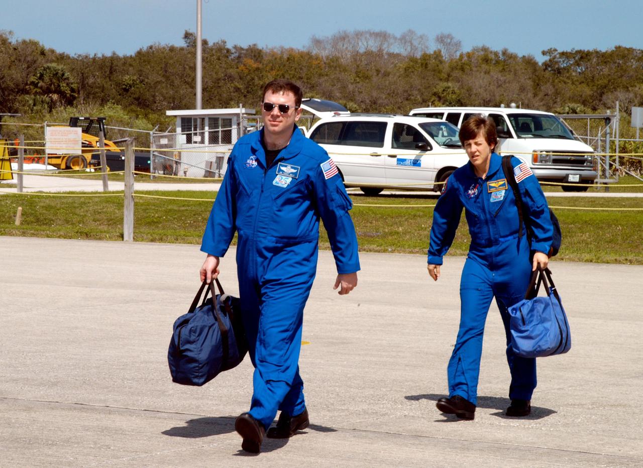 KENNEDY SPACE CENTER, FLA. -  STS-114 Pilot James Kelly (left) and Mission Specialist Wendy Lawrence cross the Shuttle Landing Facility toward the planes that will return them to Houston.  Crew members were at KSC for Shuttle and mission equipment familiarization.  The STS-114 mission is Logistics Flight 1, which is scheduled to deliver supplies and equipment, plus the external stowage platform, to the International Space Station.