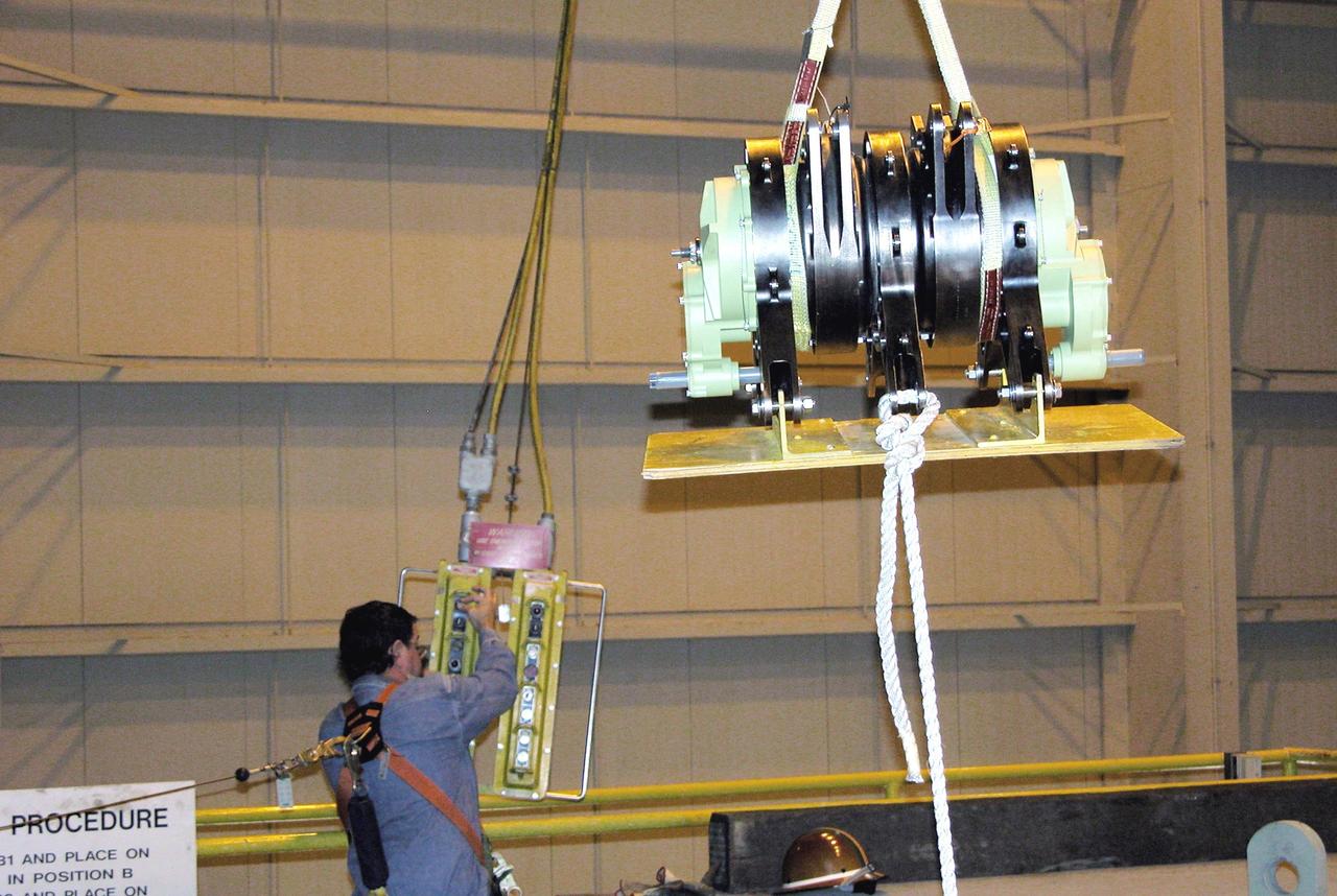 KENNEDY SPACE CENTER, FLA. - One of four rudder speed brake actuators is lifted for transfer to a pallet where it will be X-rayed.  The actuators, to be installed on the orbiter Discovery, are being X-rayed at the Radiographic High-Energy X-ray Facility at Cape Canaveral Air Force Station to determine if the gears were installed correctly. Discovery has been assigned to the first Return to Flight mission, STS-114, a logistics flight to the International Space Station.