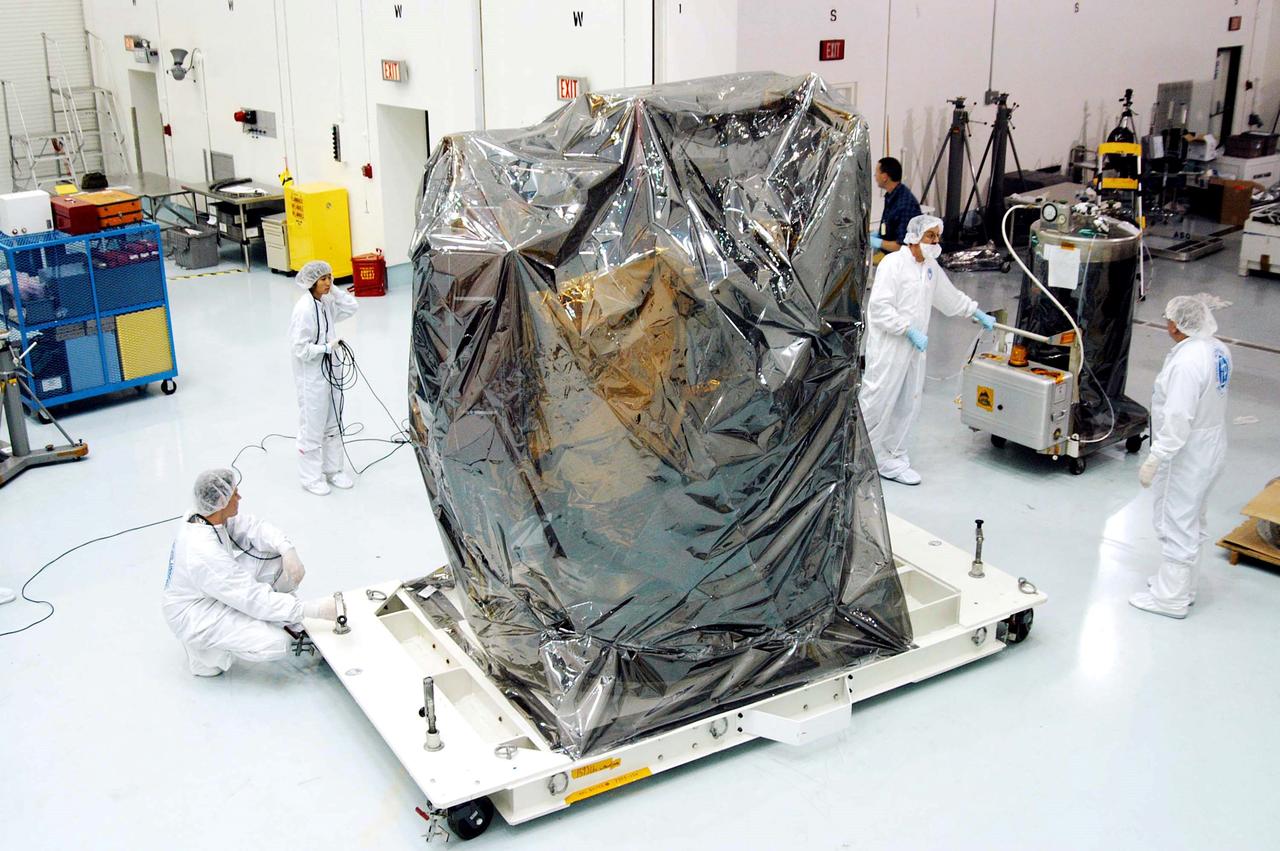 KENNEDY SPACE CENTER, FLA. -  In the high bay clean room at the Astrotech Space Operations processing facilities near KSC, workers get ready to remove the protective cover from NASA’s MESSENGER spacecraft.  Employees of the Johns Hopkins University Applied Physics Laboratory, builders of the spacecraft, will perform an initial state-of-health check.  Then processing for launch can begin, including checkout of the power systems, communications systems and control systems.  The thermal blankets will also be attached for flight.  MESSENGER - short for MErcury Surface, Space ENvironment, GEochemistry and Ranging - will be launched May 11 on a six-year mission aboard a Boeing Delta II rocket.  Liftoff is targeted for 2:26 a.m. EDT on Tuesday, May 11.
