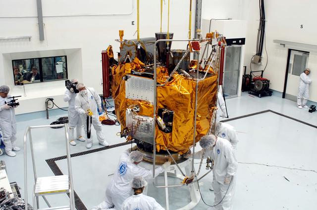 NASA image: KENNEDY SPACE CENTER, FLA. -  At the Astrotech Space Operations processing facilities, workers check the placement of NASA’s MESSENGER spacecraft on a work stand. There employees of the Johns Hopkins University Applied Physics Laboratory, builders of the spacecraft, will perform an initial state-of-health check.  Then processing for launch can begin, including checkout of the power systems, communications systems and control systems.  The thermal blankets will also be attached for flight.  MESSENGER - short for MErcury Surface, Space ENvironment, GEochemistry and Ranging - will be launched May 11 on a six-year mission aboard a Boeing Delta II rocket.  Liftoff is targeted for 2:26 a.m. EDT on Tuesday, May 11.