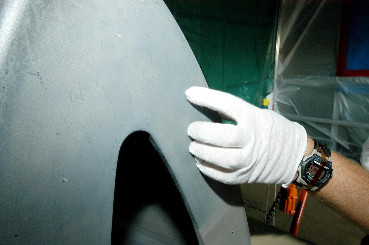 KENNEDY SPACE CENTER, FLA. -  Jim Landy, NDE specialist with USA, points to   an area of a Reinforced Carbon Carbon panel just examined using flash thermography. A relatively new procedure at KSC, thermography uses high intensity light to heat areas of the panels. The panels are then immediately scanned with an infrared camera. As the panels cool, any internal flaws are revealed. The gray carbon composite RCC panels are attached to the leading edge of the wing of the orbiters.  They have sufficient strength to withstand the aerodynamic forces experienced during launch and reentry, which can reach as high as 800 pounds per square foot.  The operating range of RCC is from minus 250º F to about 3,000º F, the temperature produced by friction with the atmosphere during reentry.  The panels will be installed on the orbiter Discovery, designated  for the first Return to Flight mission, STS-114.