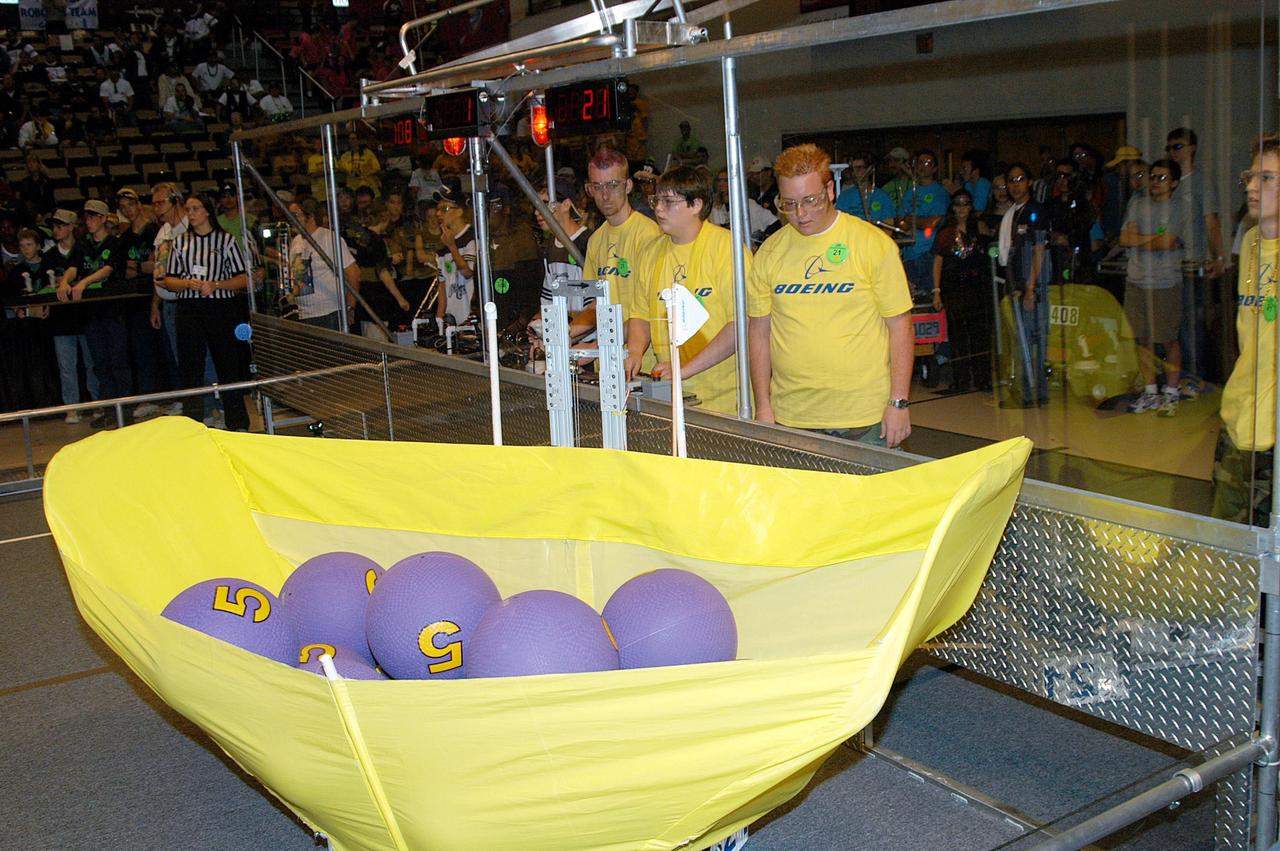 KENNEDY SPACE CENTER, FLA. -  At the University of Central Florida Arena, the Boeing-sponsored ComBBat team of students maneuver their robots to collect and pass the balls as required in the 2004 Florida Regional FIRST competition. The event hosted 41 teams from Canada, Brazil, Great Britain and the United States.  Among observers at the annual event were Center Director Jim Kennedy and Florida Gov. Jeb Bush, who spoke at the event luncheon.  FIRST is a nonprofit organization, For Inspiration and Recognition of Science and Technology, that sponsors the event pitting gladiator robots against each other in an athletic-style competition. The FIRST robotics competition is designed to provide students with a hands-on, inside look at engineering and other professional careers, pairing high school students with engineer mentors and corporations.