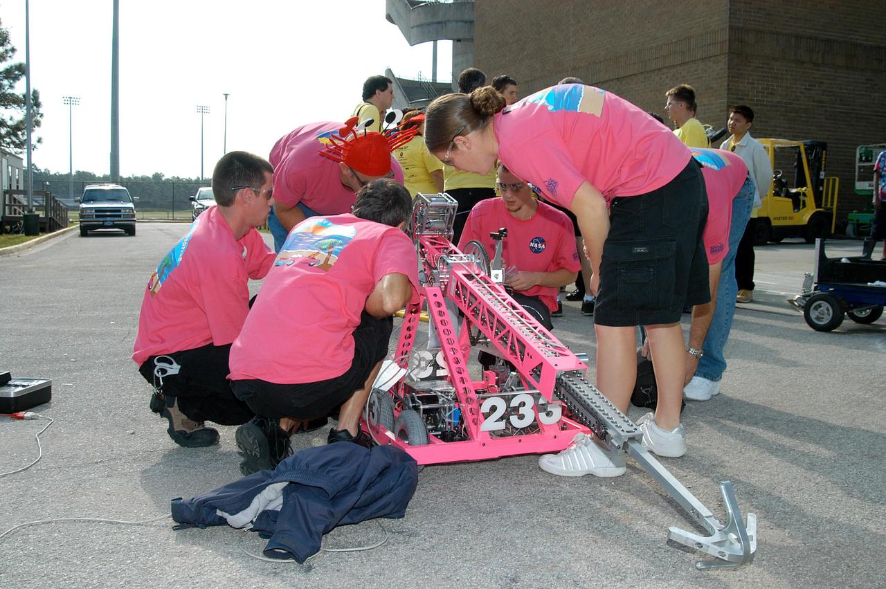 KENNEDY SPACE CENTER, FLA. -  On the grounds of the University of Central Florida, the KSC-sponsored “Pink” team checks out its robot for the 2004 Florida Regional FIRST competition.  The event hosted 41 teams from Canada, Brazil, Great Britain and the United States.  Among observers at the annual event were Center Director Jim Kennedy and Florida Gov. Jeb Bush, who spoke at the event luncheon.  FIRST is a nonprofit organization, For Inspiration and Recognition of Science and Technology, that sponsors the event pitting gladiator robots against each other in an athletic-style competition. The FIRST robotics competition is designed to provide students with a hands-on, inside look at engineering and other professional careers, pairing high school students with engineer mentors and corporations.