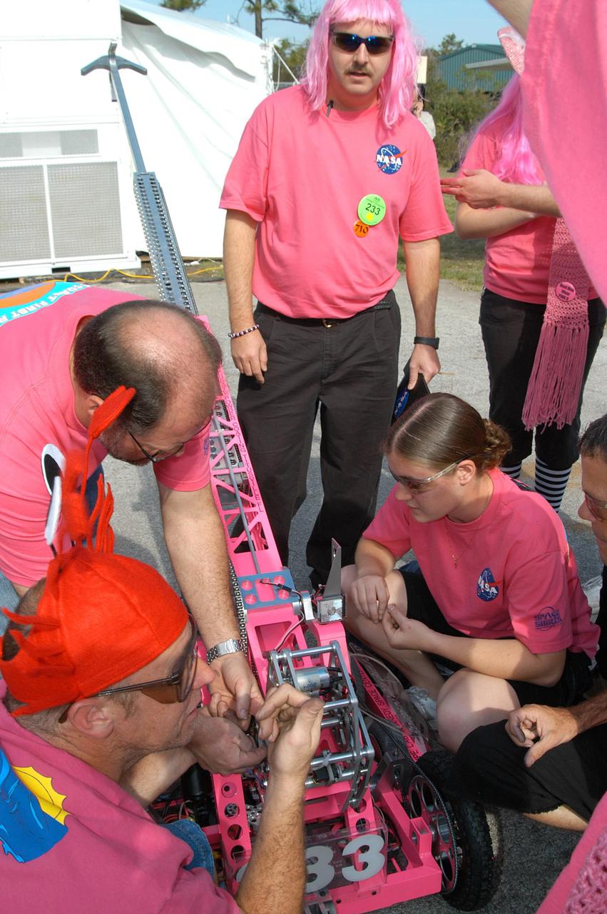 KENNEDY SPACE CENTER, FLA. -  On the grounds of the University of Central Florida, the KSC-sponsored “Pink” team checks out its robot for the 2004 Florida Regional FIRST competition.  The event hosted 41 teams from Canada, Brazil, Great Britain and the United States.  Among observers at the annual event were Center Director Jim Kennedy and Florida Gov. Jeb Bush, who spoke at the event luncheon.  FIRST is a nonprofit organization, For Inspiration and Recognition of Science and Technology, that sponsors the event pitting gladiator robots against each other in an athletic-style competition. The FIRST robotics competition is designed to provide students with a hands-on, inside look at engineering and other professional careers, pairing high school students with engineer mentors and corporations.