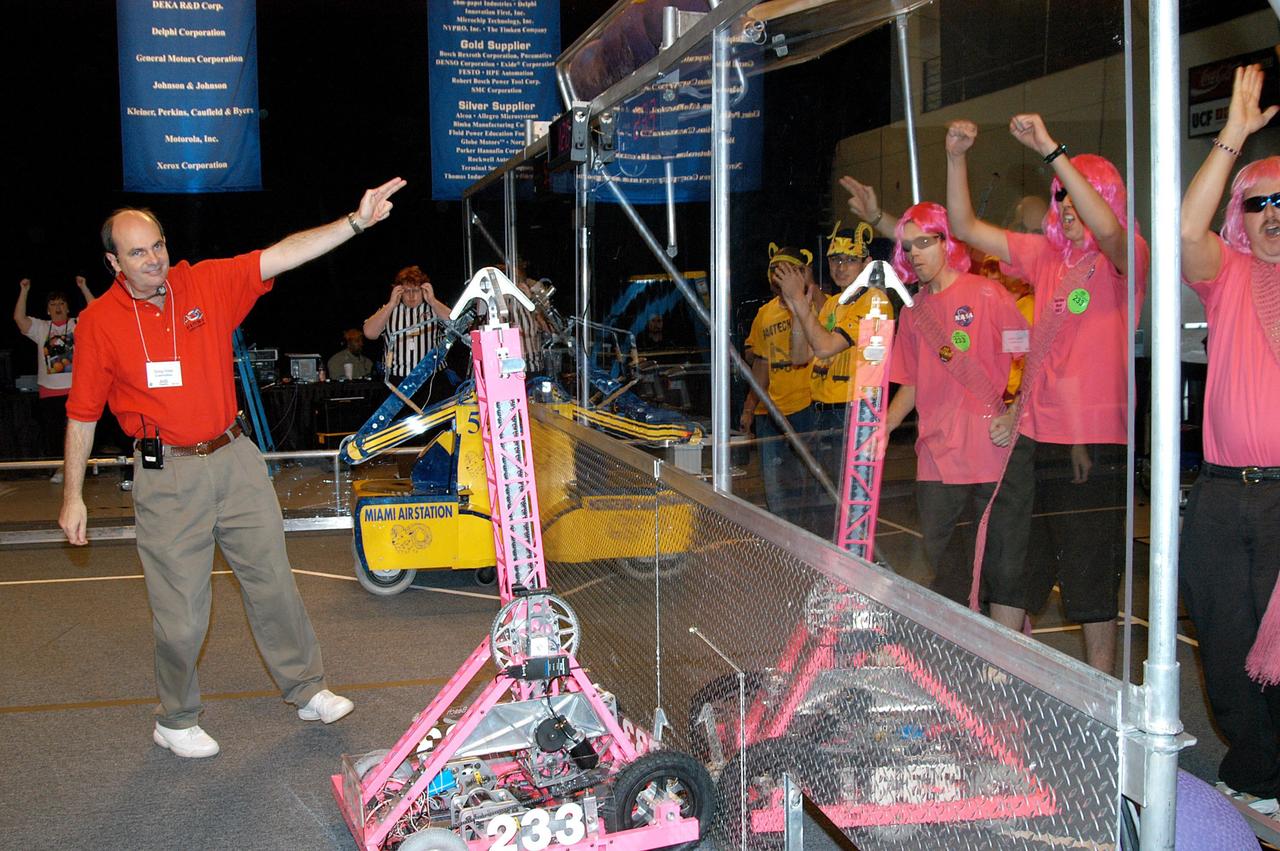 KENNEDY SPACE CENTER, FLA. -  During the 2004 Florida Regional FIRST competition in the University of Central Florida Arena, a judge names the KSC-sponsored “Pink” team winner of the match. The event hosted 41 teams from Canada, Brazil, Great Britain and the United States.  Among observers at the annual event were Center Director Jim Kennedy and Florida Gov. Jeb Bush, who spoke at the event luncheon.  FIRST is a nonprofit organization, For Inspiration and Recognition of Science and Technology, that sponsors the event pitting gladiator robots against each other in an athletic-style competition. The FIRST robotics competition is designed to provide students with a hands-on, inside look at engineering and other professional careers, pairing high school students with engineer mentors and corporations.