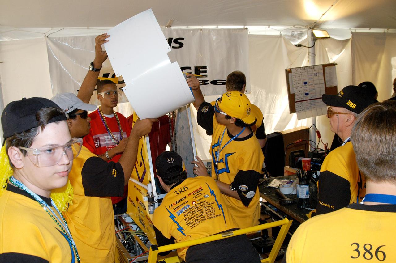 KENNEDY SPACE CENTER, FLA. -  This Central Florida team works on its robot before a match in the 2004 Florida Regional FIRST competition in the University of Central Florida Arena. The event hosted 41 teams from Canada, Brazil, Great Britain and the United States.  Among observers at the annual event were Center Director Jim Kennedy and Florida Gov. Jeb Bush, who both spoke at the event luncheon.  FIRST is a nonprofit organization, For Inspiration and Recognition of Science and Technology, that sponsors the event pitting gladiator robots against each other in an athletic-style competition. The FIRST robotics competition is designed to provide students with a hands-on, inside look at engineering and other professional careers, pairing high school students with engineer mentors and corporations.